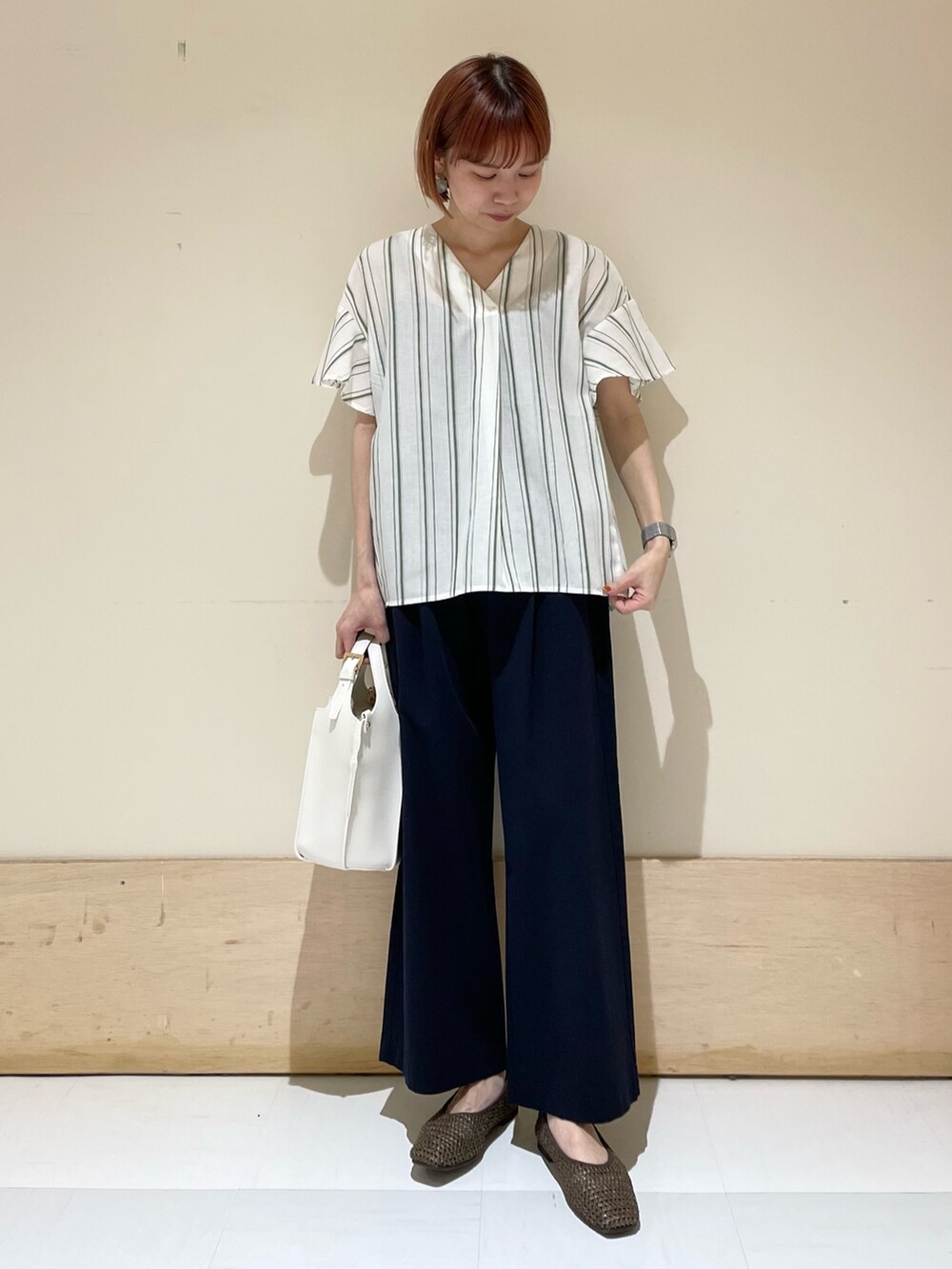 グリーン系のシャツ/ブラウス、ブルー系のその他パンツ、ホワイト系のトートバッグを着用したレディースの春コーディネートの3枚目の写真