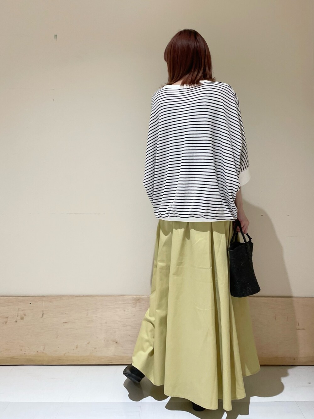 ホワイト系のTシャツ/カットソー、イエロー系のスカート、ブラック系のローファーを着用したレディースの春コーディネートの5枚目の写真