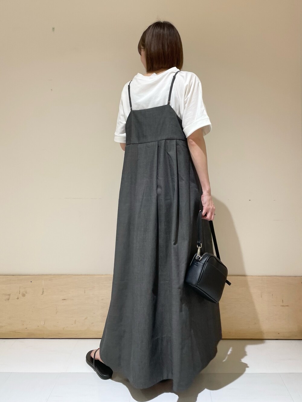 ブラック系のワンピース、ブラック系のショルダーバッグ、ブラック系のサンダルを着用したレディースの夏コーディネートの6枚目の写真