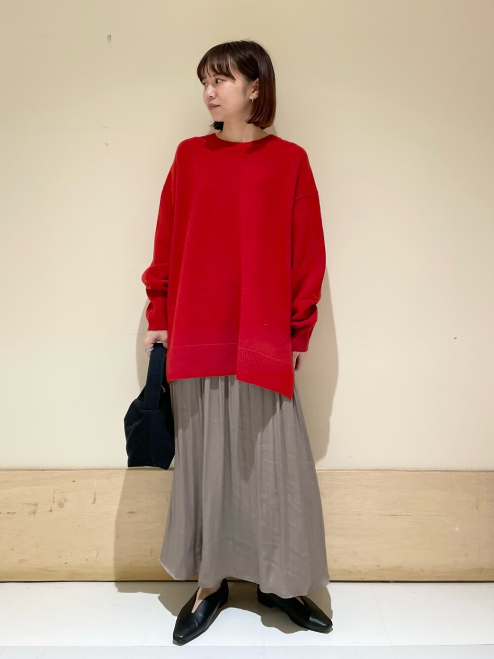 ブラック系のハンドバッグ、グレー系のスカート、ブラック系のパンプスを着用したレディースの秋コーディネートの2枚目の写真