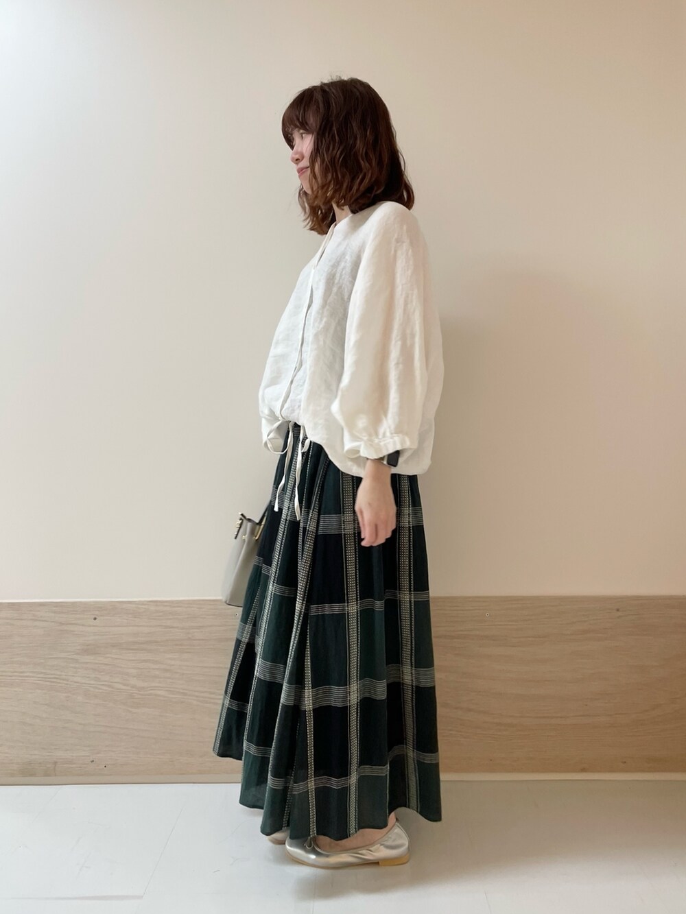 ホワイト系のシャツ/ブラウス、グリーン系のスカート、シルバー系のバレエシューズを着用したレディースの春コーディネートの3枚目の写真