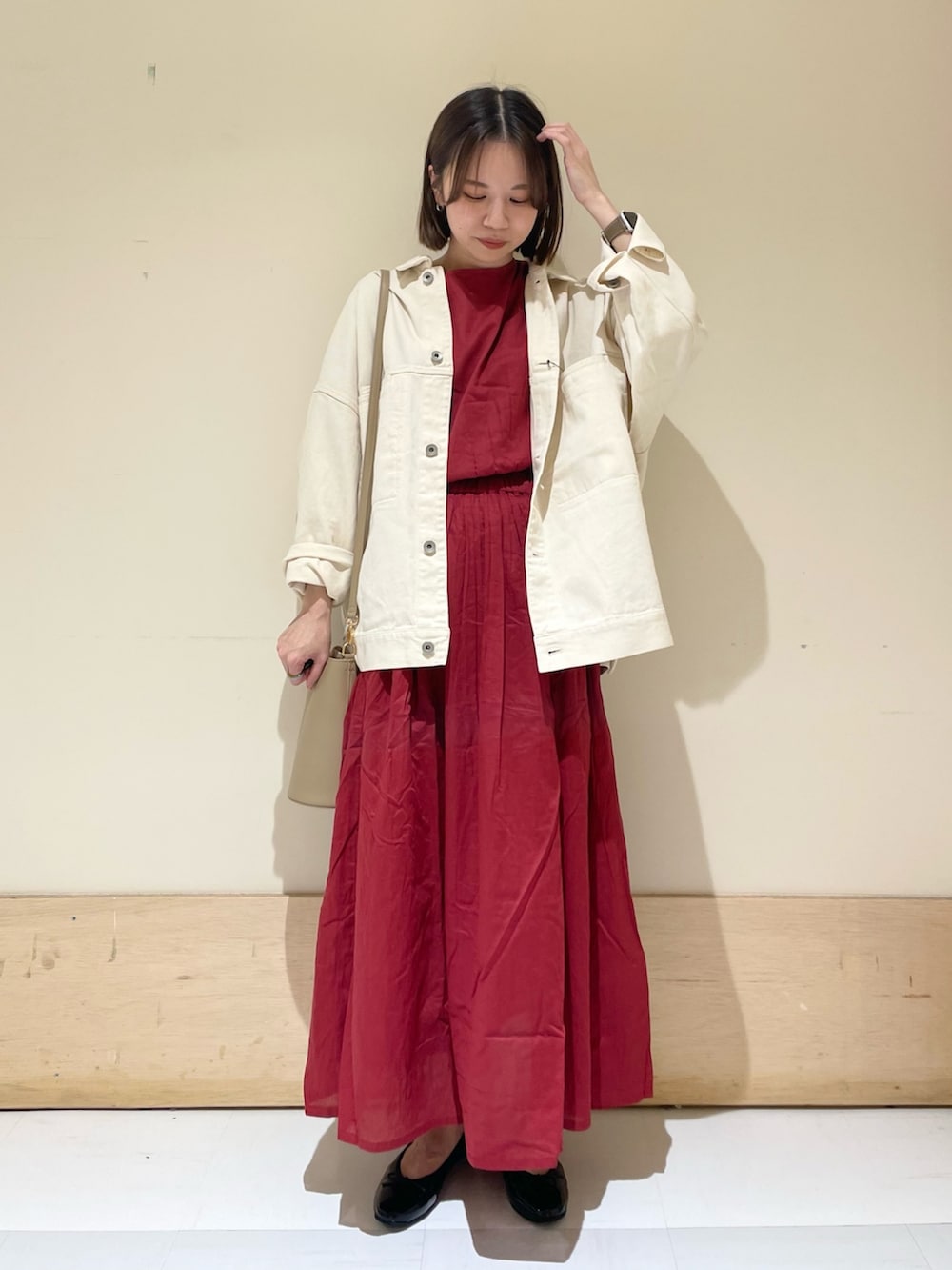 ブラック系のパンプス、ベージュ系のショルダーバッグ、レッド系のワンピースを着用したレディースの秋コーディネートの2枚目の写真