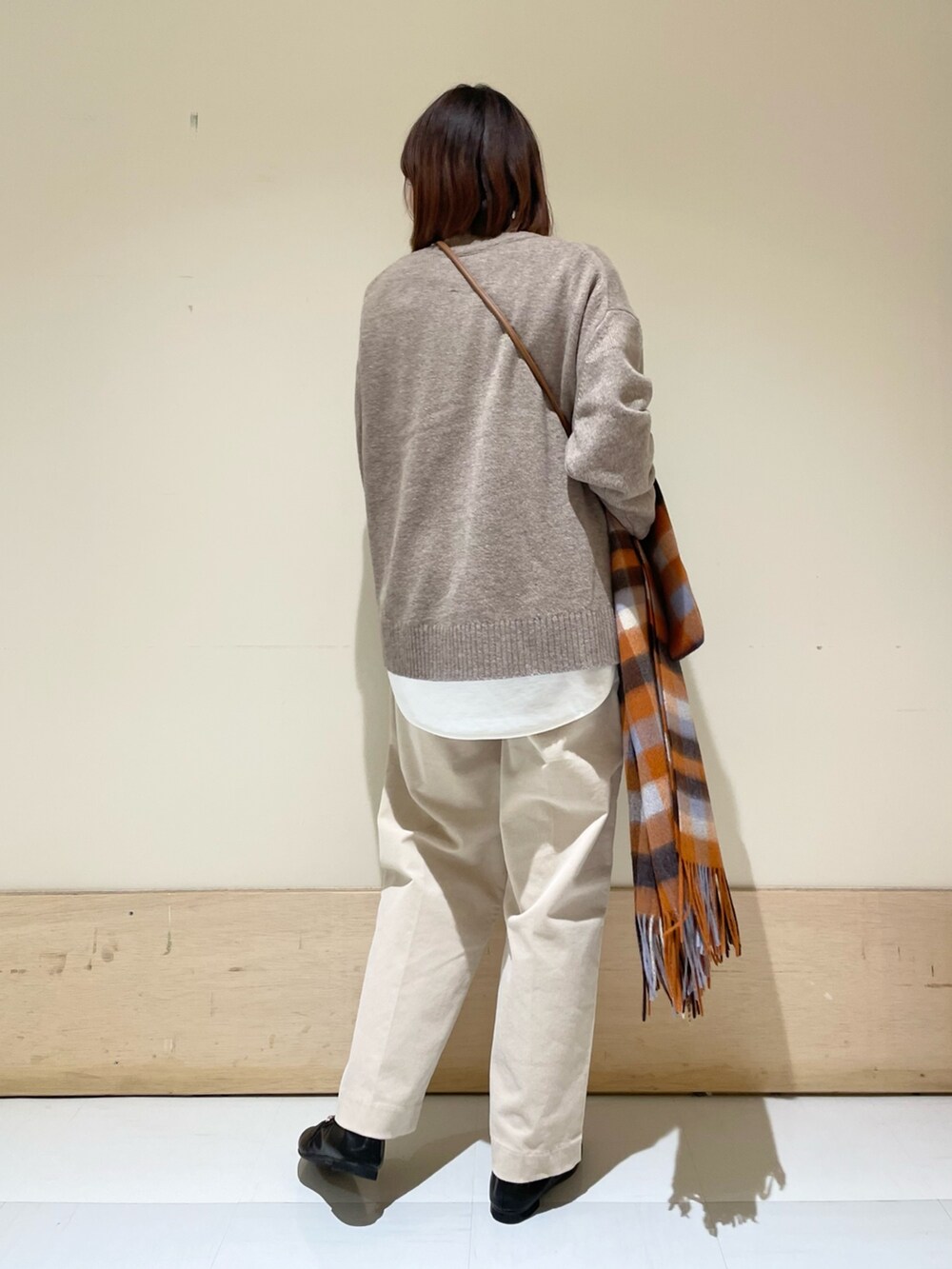 ホワイト系のTシャツ/カットソー、ブラウン系のニット/セーター、ベージュ系のその他パンツを着用したレディースの冬コーディネートの6枚目の写真