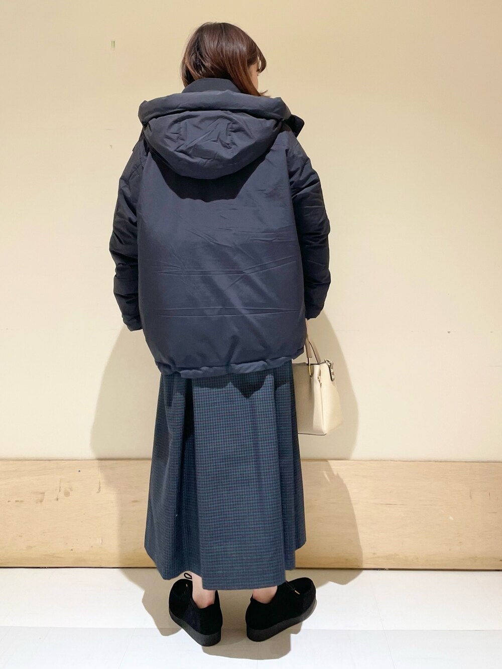 ブルー系のワンピース、ブラック系のダウンジャケット/コート、ホワイト系のTシャツ/カットソーを着用したレディースの冬コーディネートの7枚目の写真