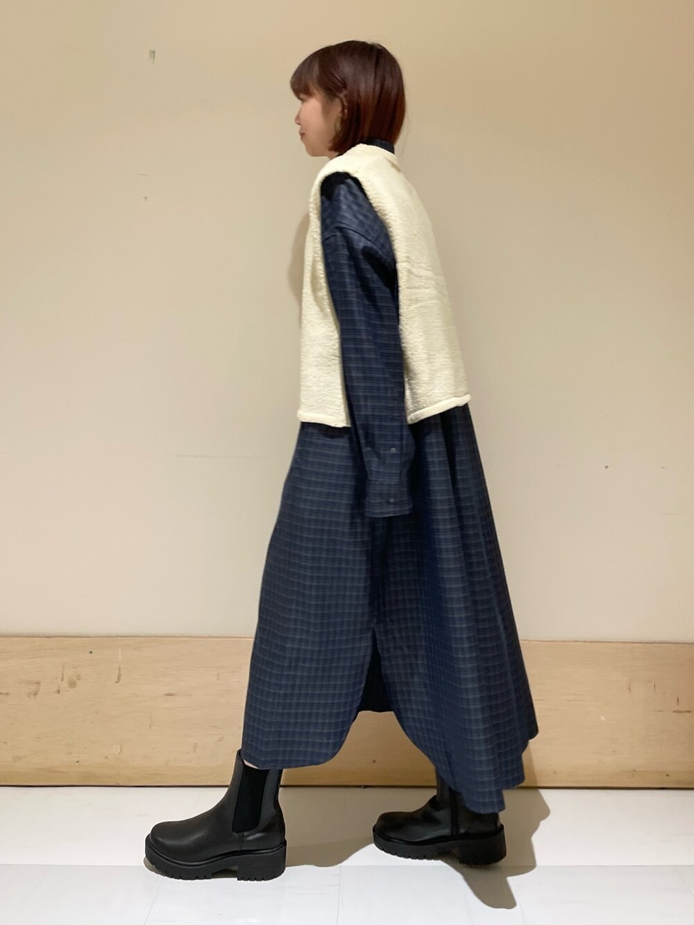 ホワイト系のベスト、グレー系のシャツワンピース、ブラック系のトートバッグを着用したレディースの秋コーディネートの5枚目の写真