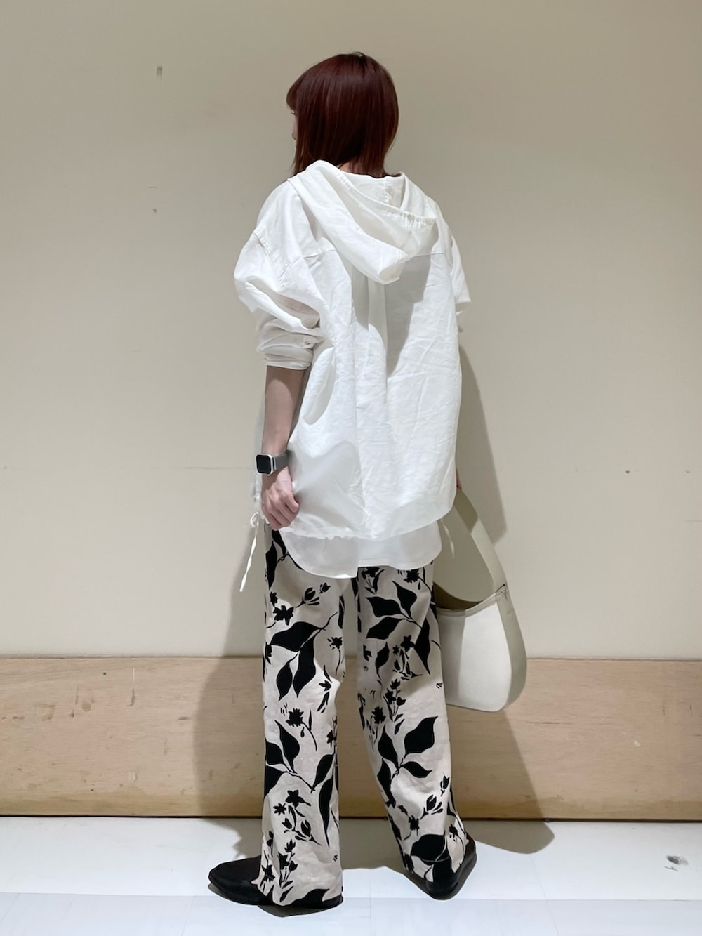 ホワイト系のパーカー、ホワイト系のタンクトップ、ベージュ系のハンドバッグを着用したレディースの春コーディネートの5枚目の写真