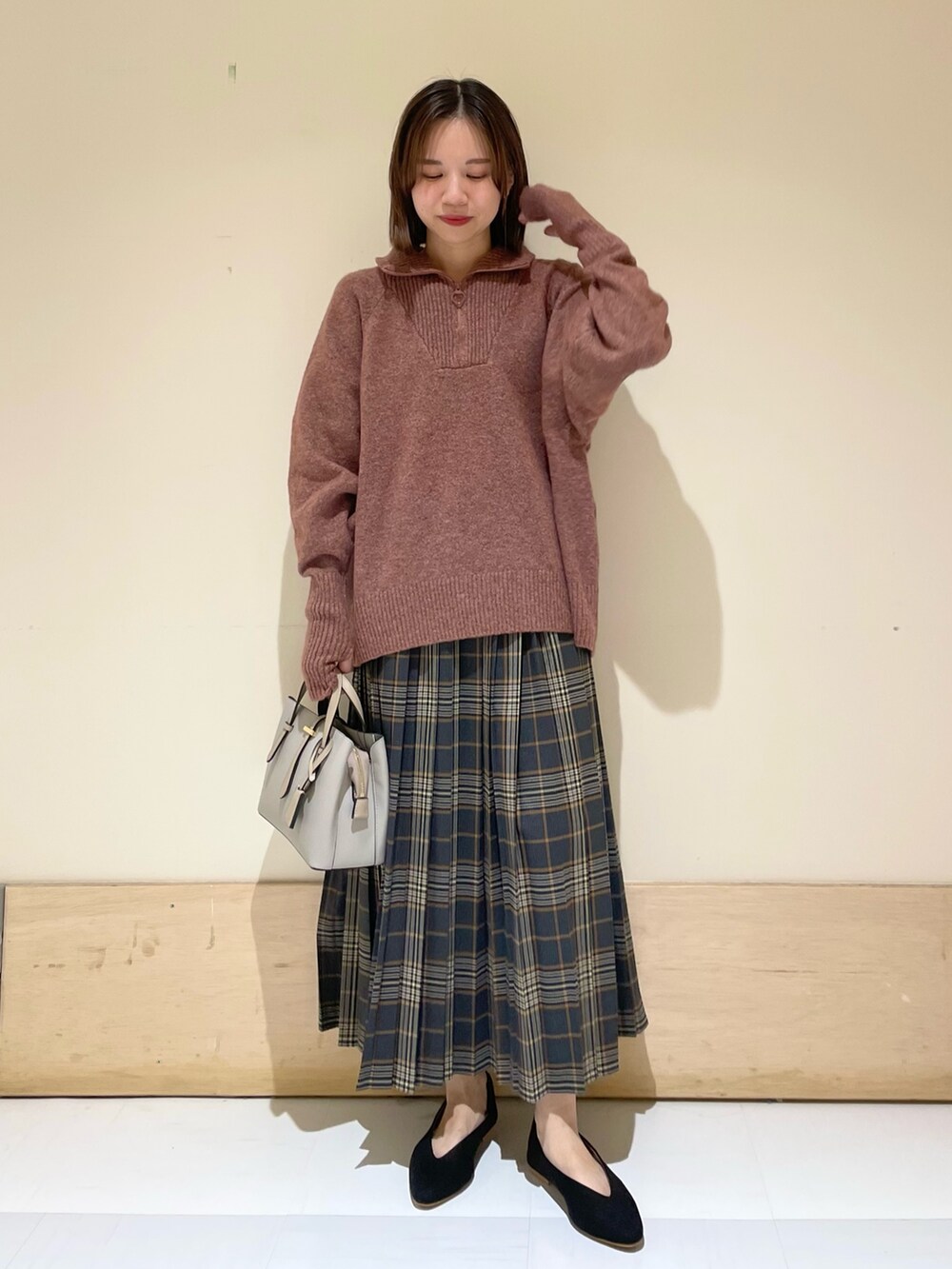 レッド系のニット/セーター、ブラック系のパンプス、グレー系のハンドバッグを着用したレディースの秋コーディネートの2枚目の写真