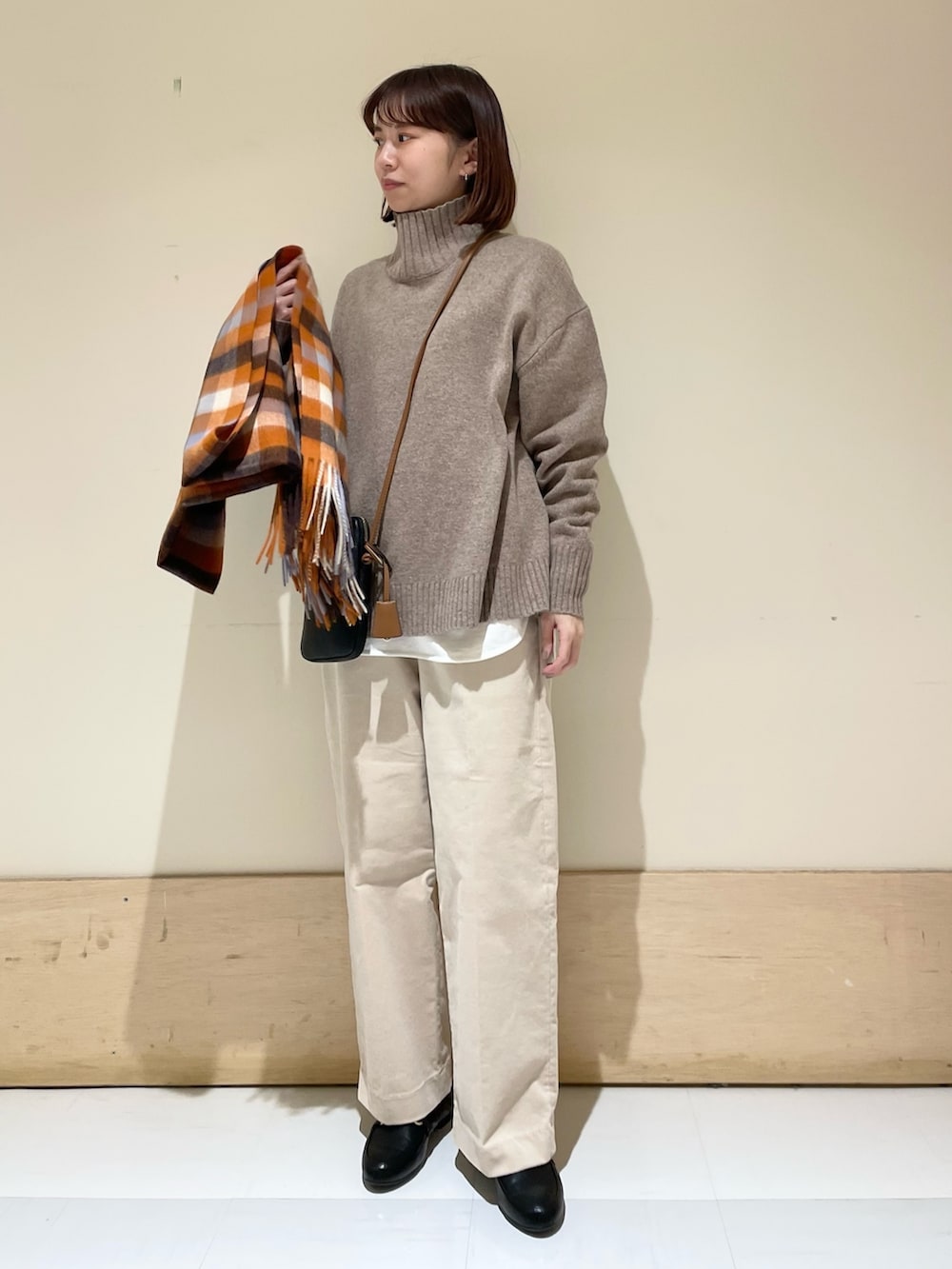 ホワイト系のTシャツ/カットソー、ブラウン系のニット/セーター、ベージュ系のその他パンツを着用したレディースの冬コーディネートの2枚目の写真