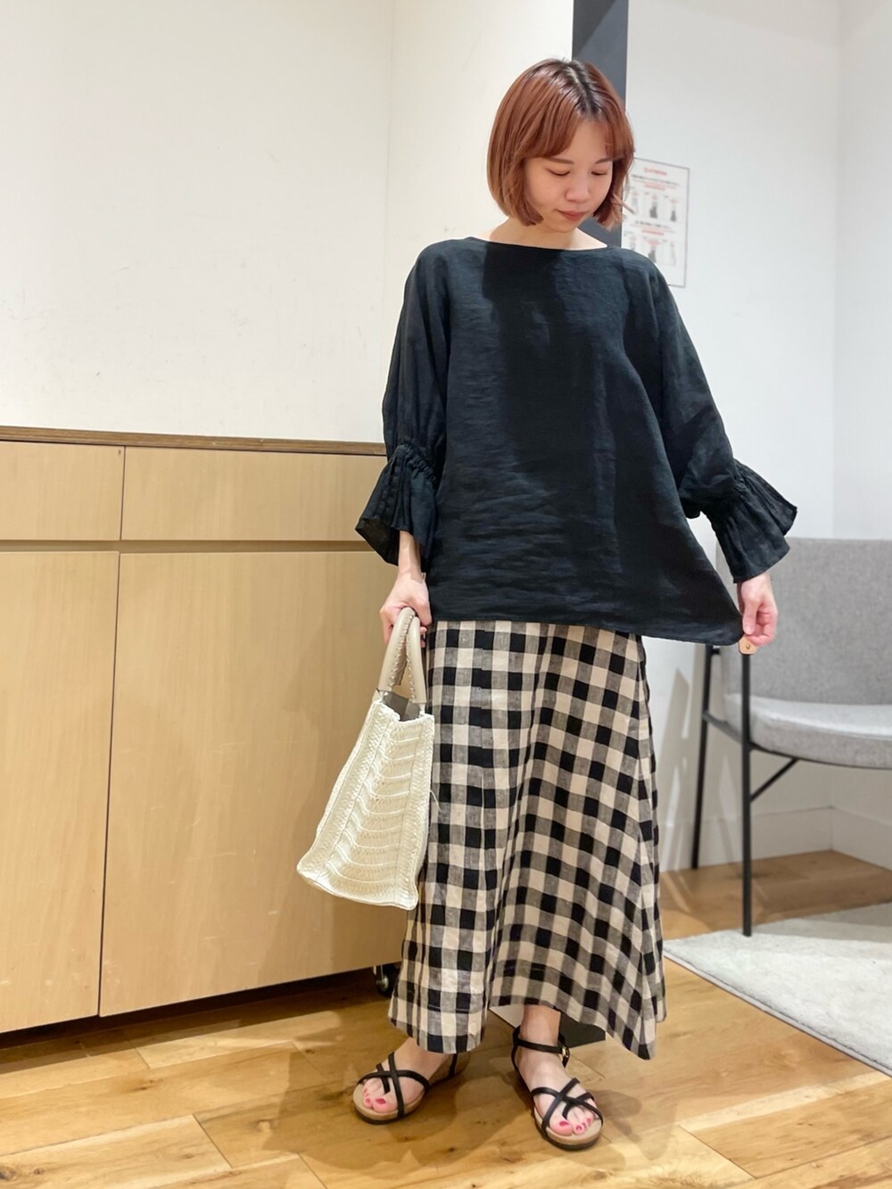 ブラック系のスカート、ベージュ系のトートバッグ、ブラック系のシャツ/ブラウスを着用したレディースの春コーディネートの3枚目の写真