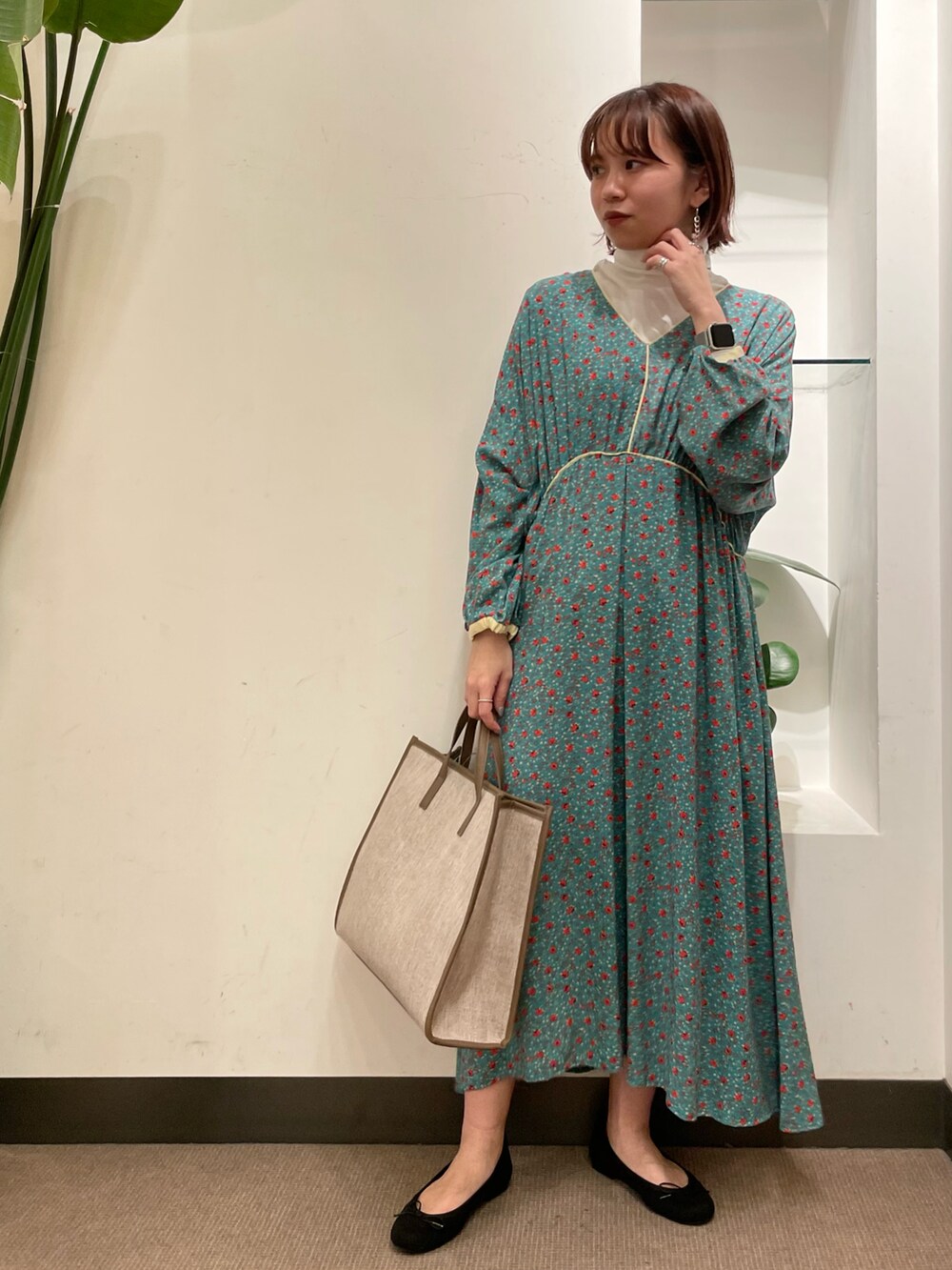 ブラック系のバレエシューズ、グリーン系のワンピース、ホワイト系のTシャツ/カットソーを着用したレディースの冬コーディネートの2枚目の写真