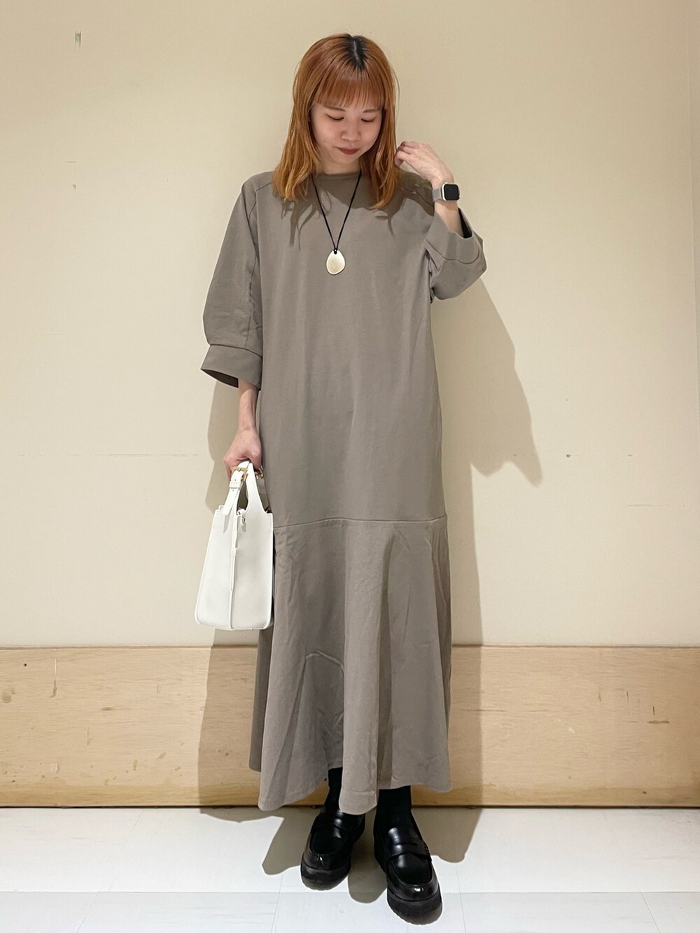 ブラウン系のワンピース、ホワイト系のトートバッグ、ブラック系のローファーを着用したレディースの春コーディネートの2枚目の写真