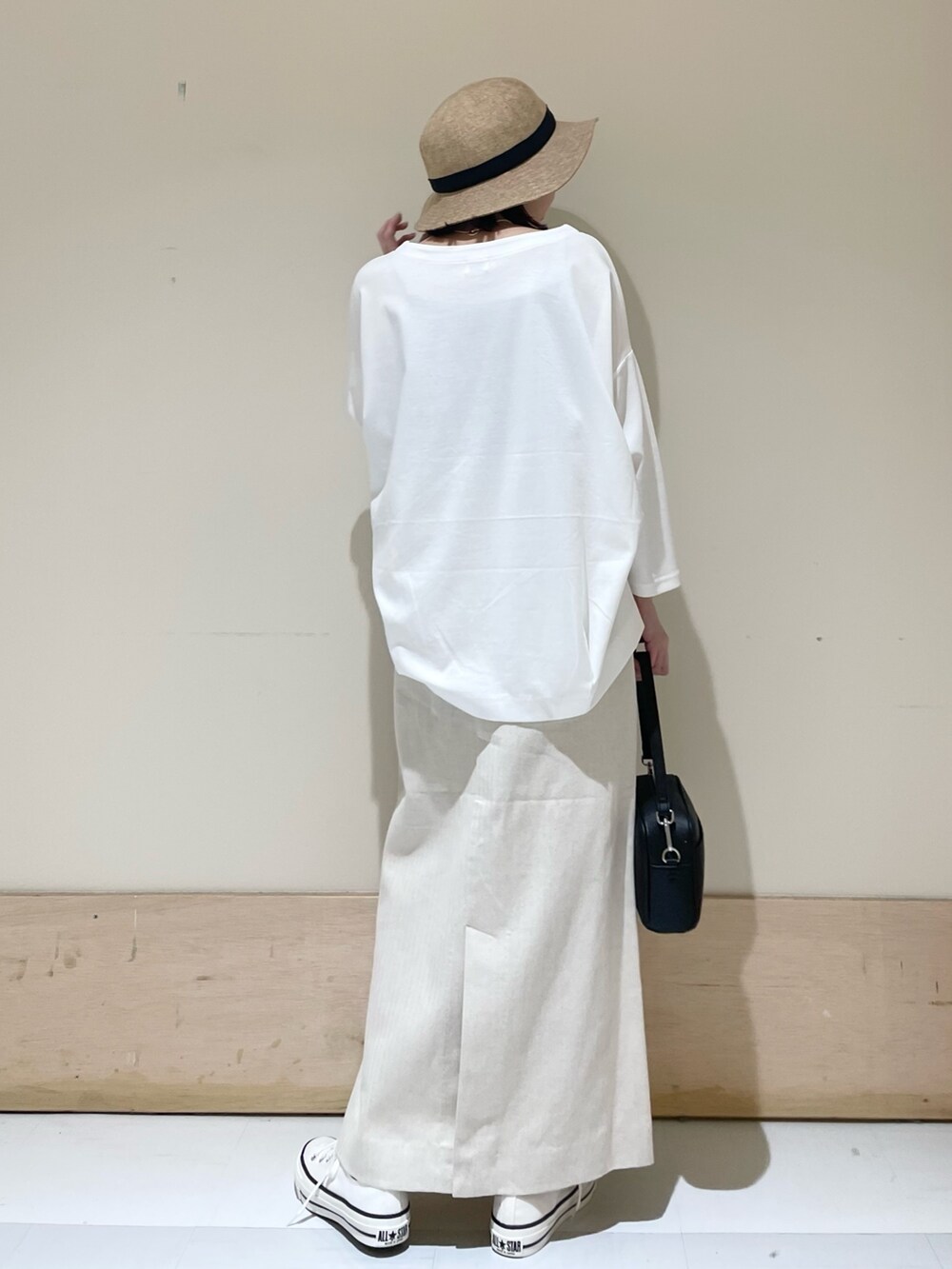 ホワイト系のTシャツ/カットソー、ホワイト系のスニーカー、ブラック系のショルダーバッグを着用したレディースの春コーディネートの6枚目の写真