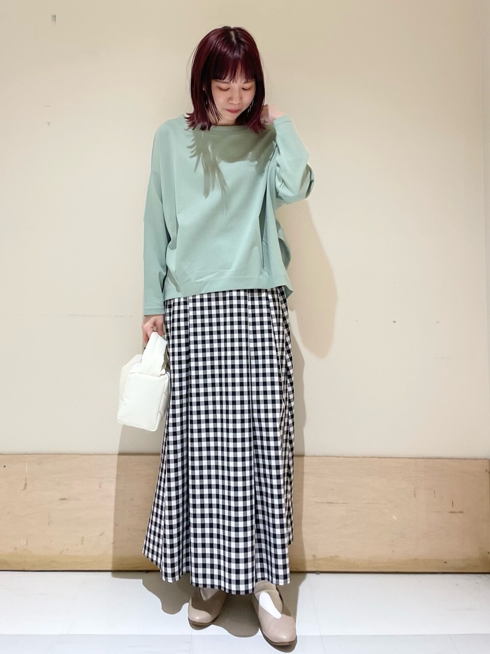 グリーン系のTシャツ/カットソー、ベージュ系のパンプス、その他のスカートを着用したレディースの春コーディネートの2枚目の写真