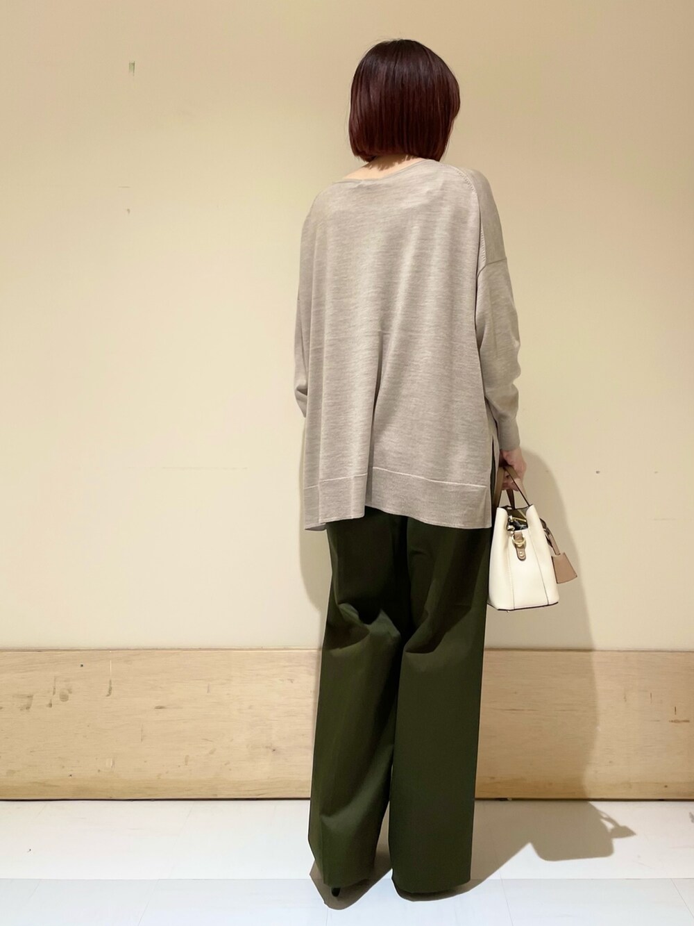ブラック系のパンプス、ベージュ系のニット/セーター、ホワイト系のハンドバッグを着用したレディースの秋コーディネートの7枚目の写真