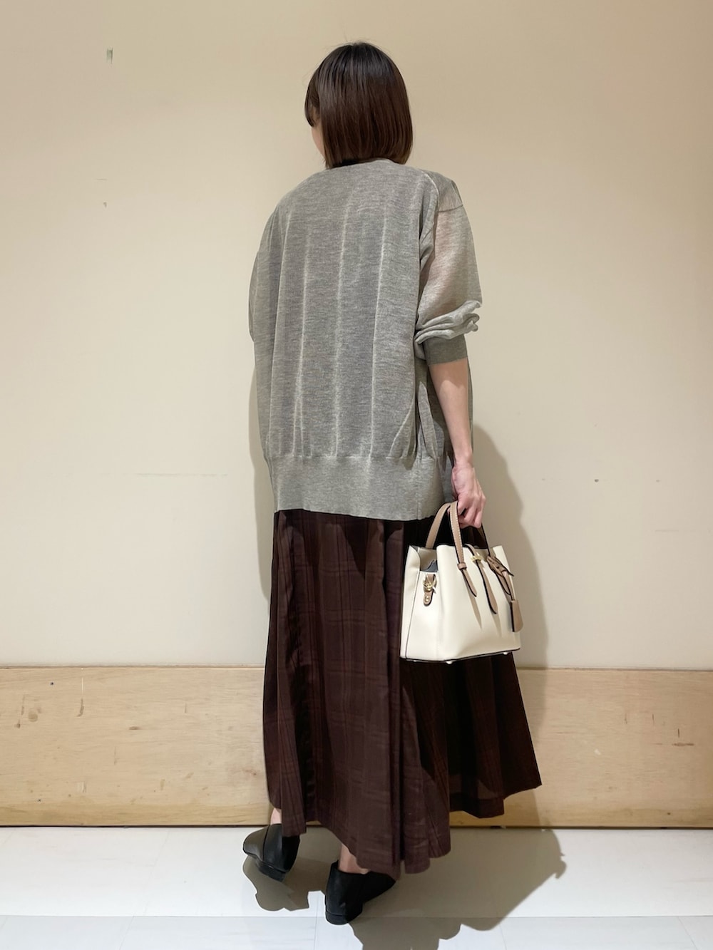 ブラウン系のワンピース、ベージュ系のカーディガン/ボレロ、ブラック系のパンプスを着用したレディースの夏コーディネートの6枚目の写真