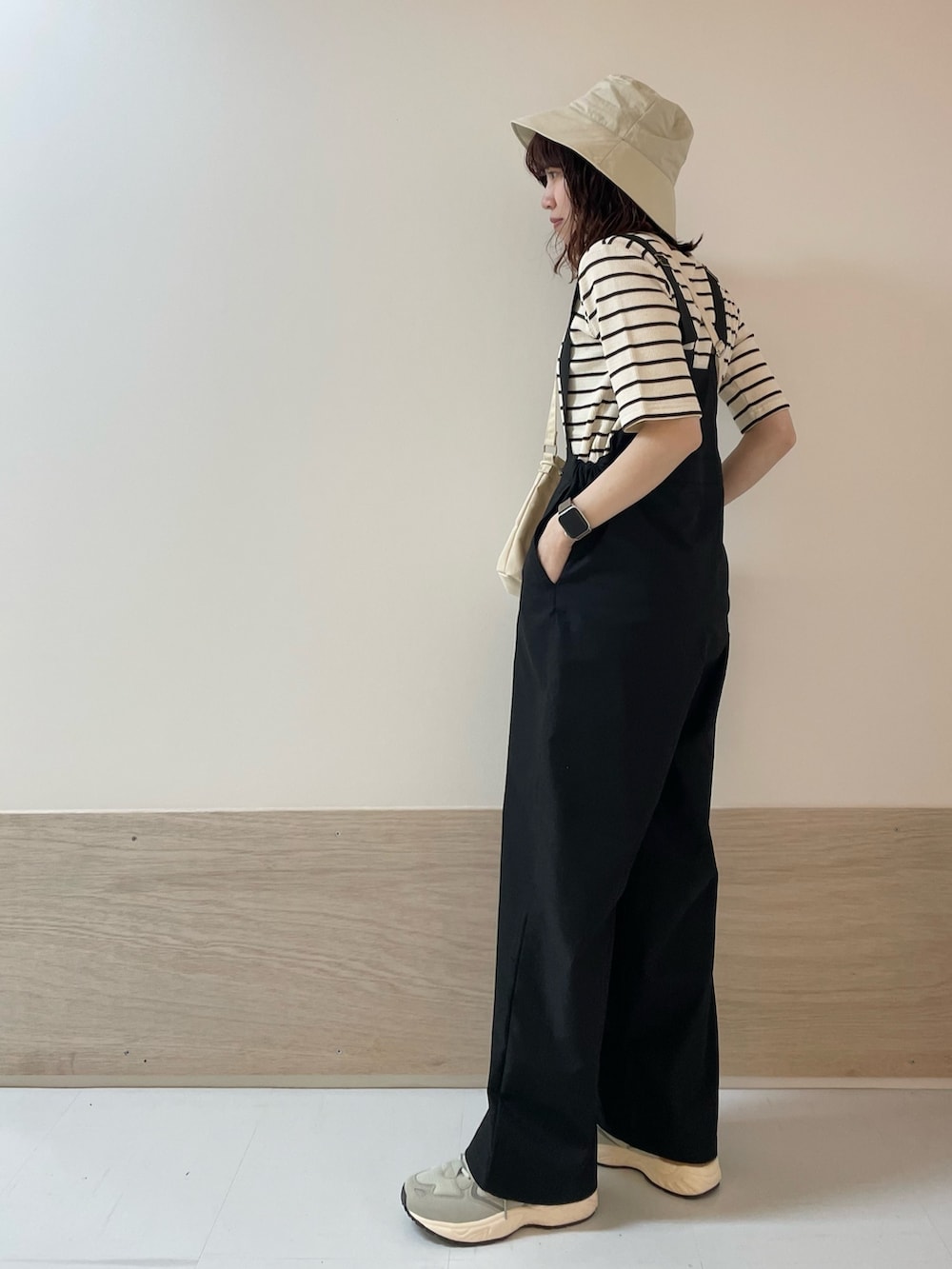 ブラウン系のTシャツ/カットソー、グレー系のスニーカー、ベージュ系のショルダーバッグを着用したレディースの春コーディネートの4枚目の写真