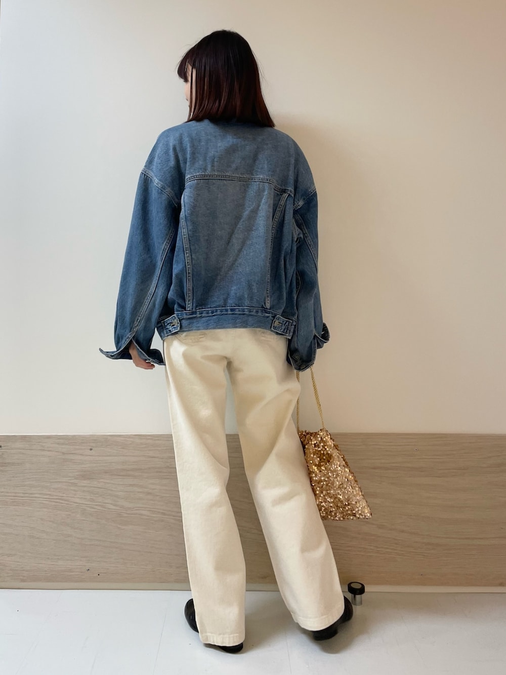 イエロー系のニット/セーター、ベージュ系のデニムパンツ、ブルー系のデニムジャケットを着用したレディースの冬コーディネートの6枚目の写真