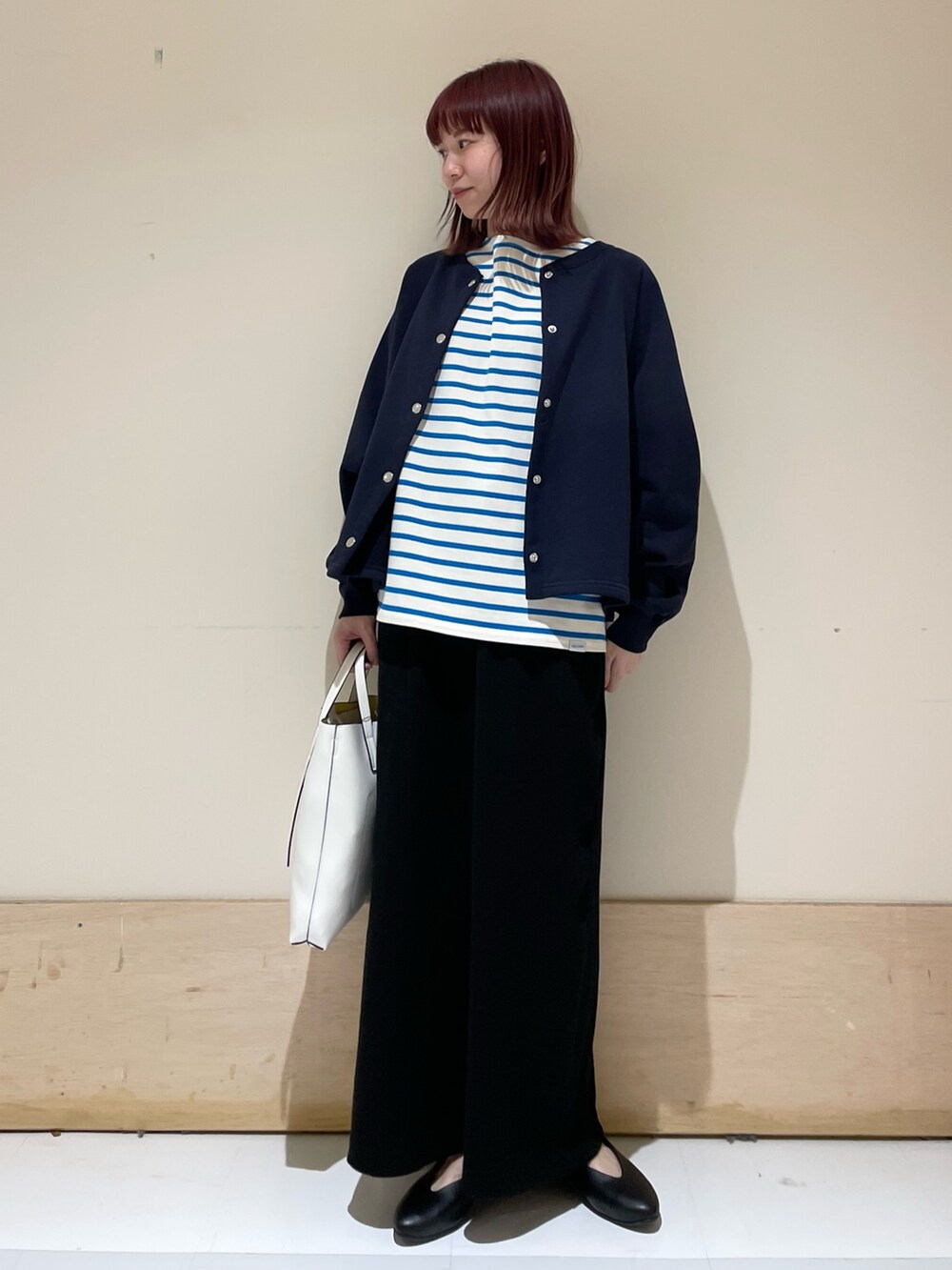 ブルー系のニット/セーター、ブルー系のTシャツ/カットソー、ブラック系のパンプスを着用したレディースの春コーディネートの3枚目の写真