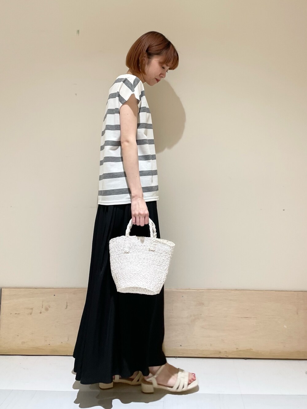 グレー系のTシャツ/カットソー、ホワイト系のハンドバッグ、ホワイト系のサンダルを着用したレディースの春コーディネートの4枚目の写真