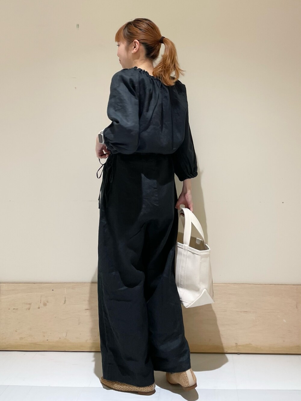 ブラック系のサロペット/オーバーオール、ベージュ系のバレエシューズ、ホワイト系のトートバッグを着用したレディースの春コーディネートの5枚目の写真