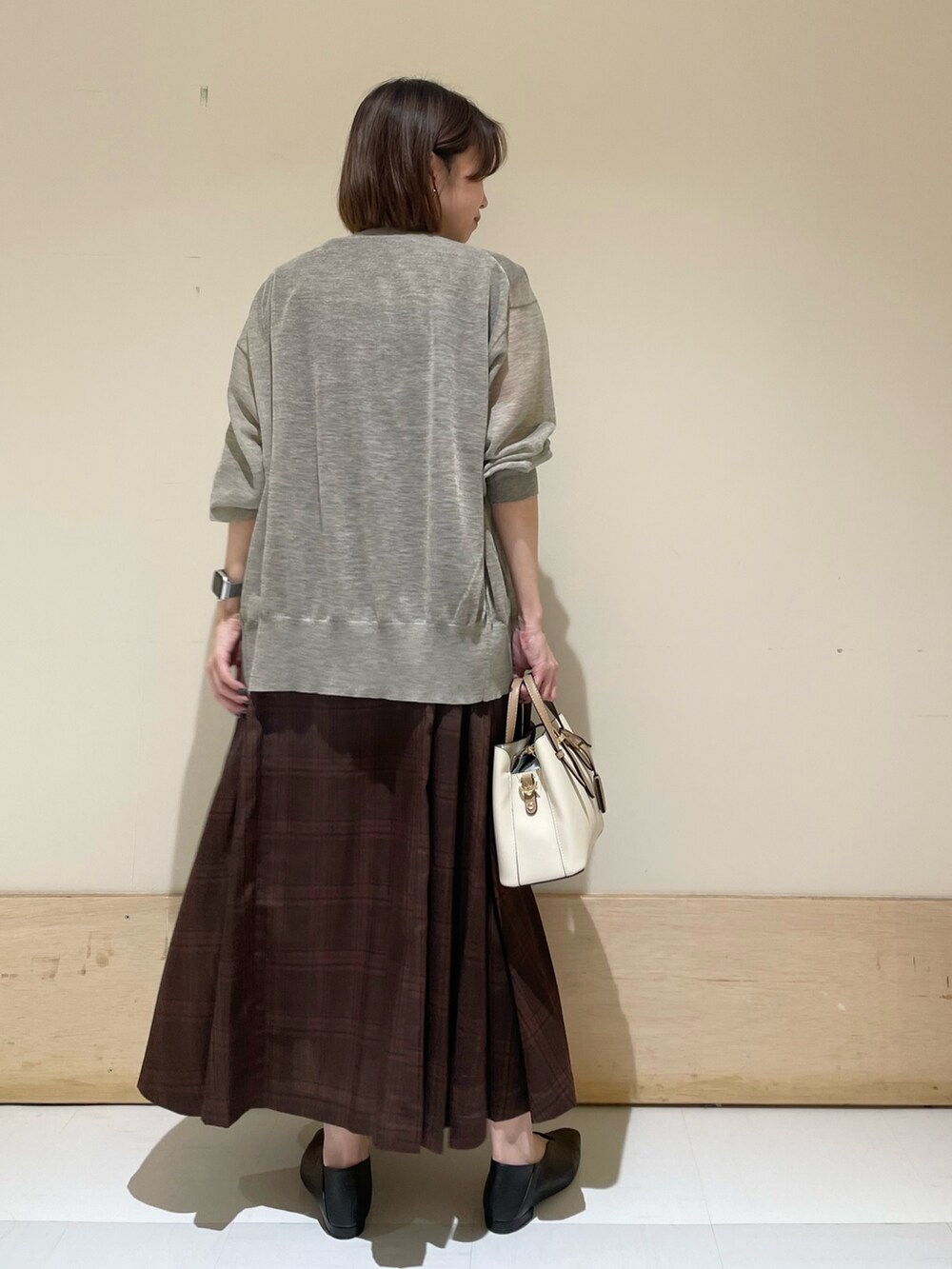 ブラウン系のワンピース、ベージュ系のカーディガン/ボレロ、ブラック系のパンプスを着用したレディースの夏コーディネートの7枚目の写真