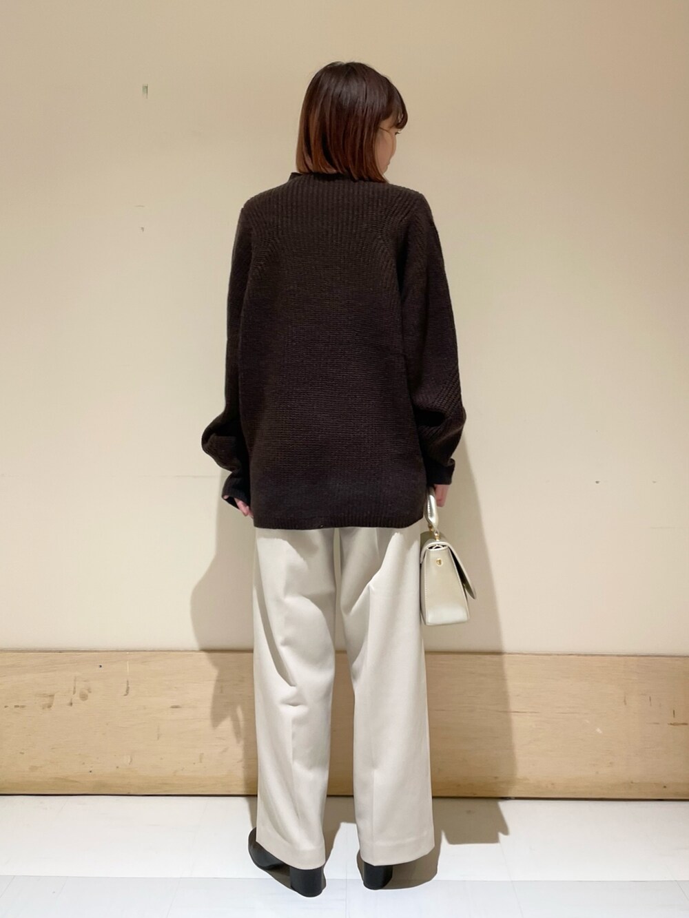 ブラウン系のニット/セーター、ゴールド系のショルダーバッグ、ホワイト系のその他パンツを着用したレディースの冬コーディネートの7枚目の写真