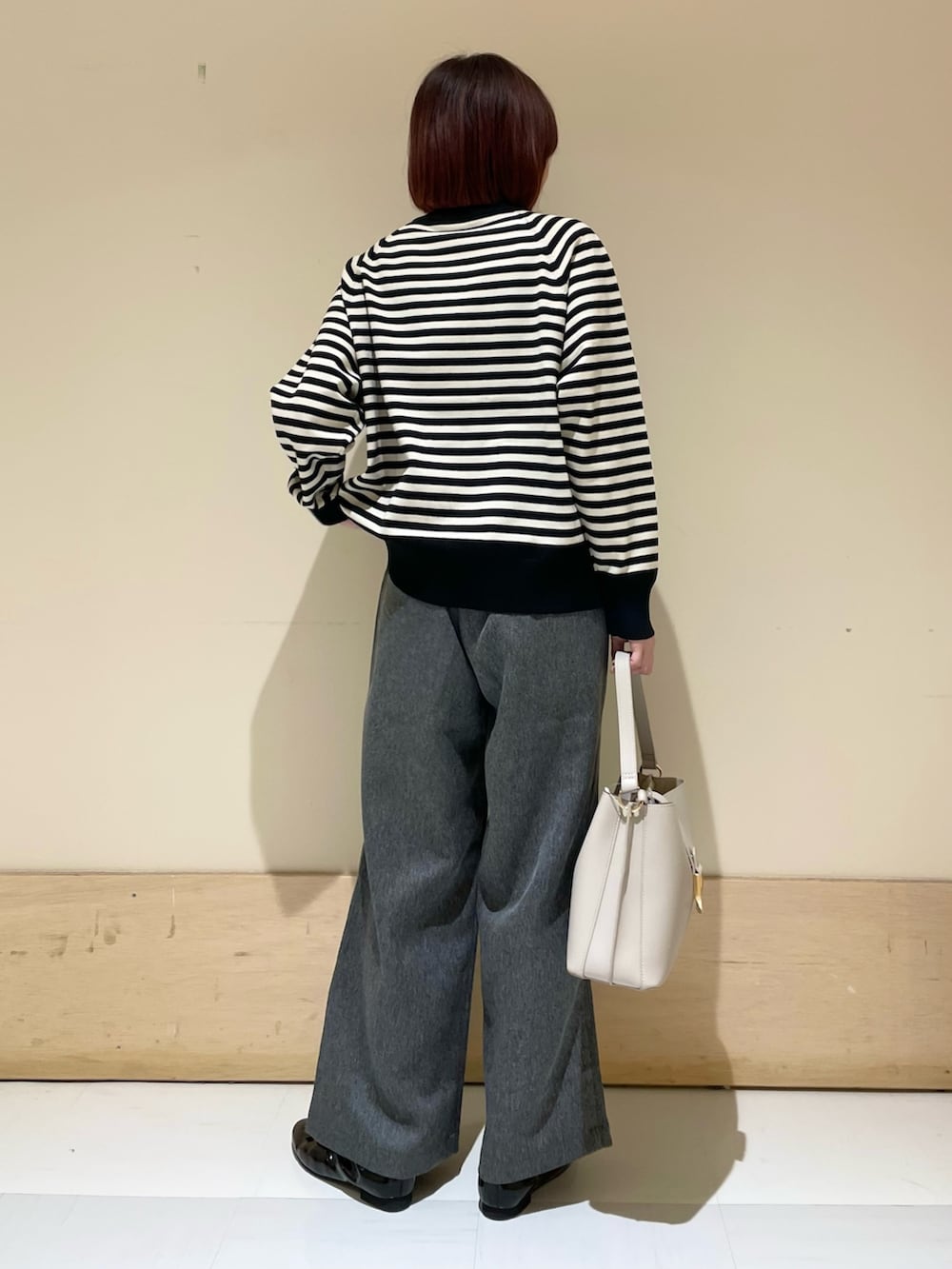 グレー系のその他パンツ、グレー系のハンドバッグ、ブラック系のパンプスを着用したレディースの秋コーディネートの6枚目の写真