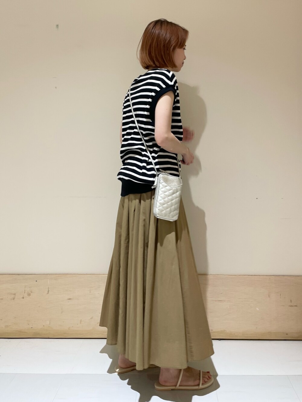 ベージュ系のスカート、ホワイト系のサンダル、ブラック系のTシャツ/カットソーを着用したレディースの夏コーディネートの4枚目の写真