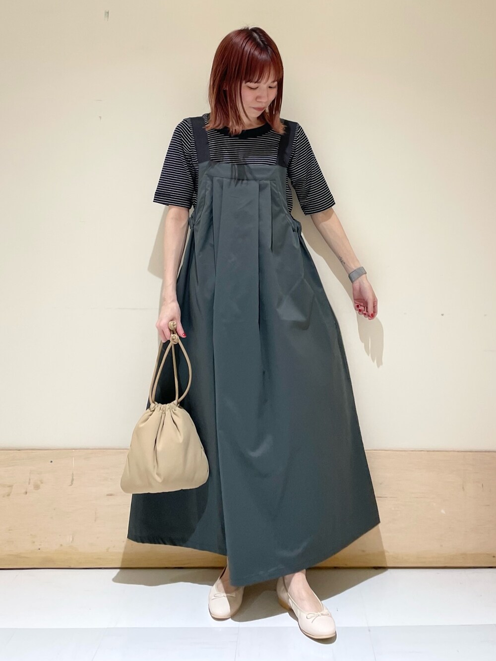 ベージュ系のショルダーバッグ、ピンク系のバレエシューズ、ホワイト系のTシャツ/カットソーを着用したレディースの春コーディネートの2枚目の写真