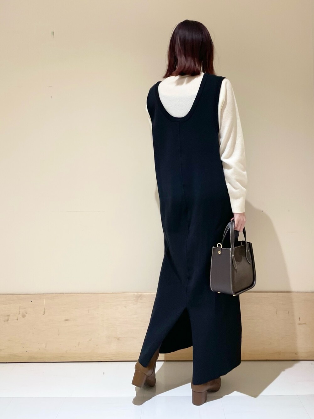 ブラック系のワンピース、ホワイト系のニット/セーターを着用したレディースの冬コーディネートの6枚目の写真