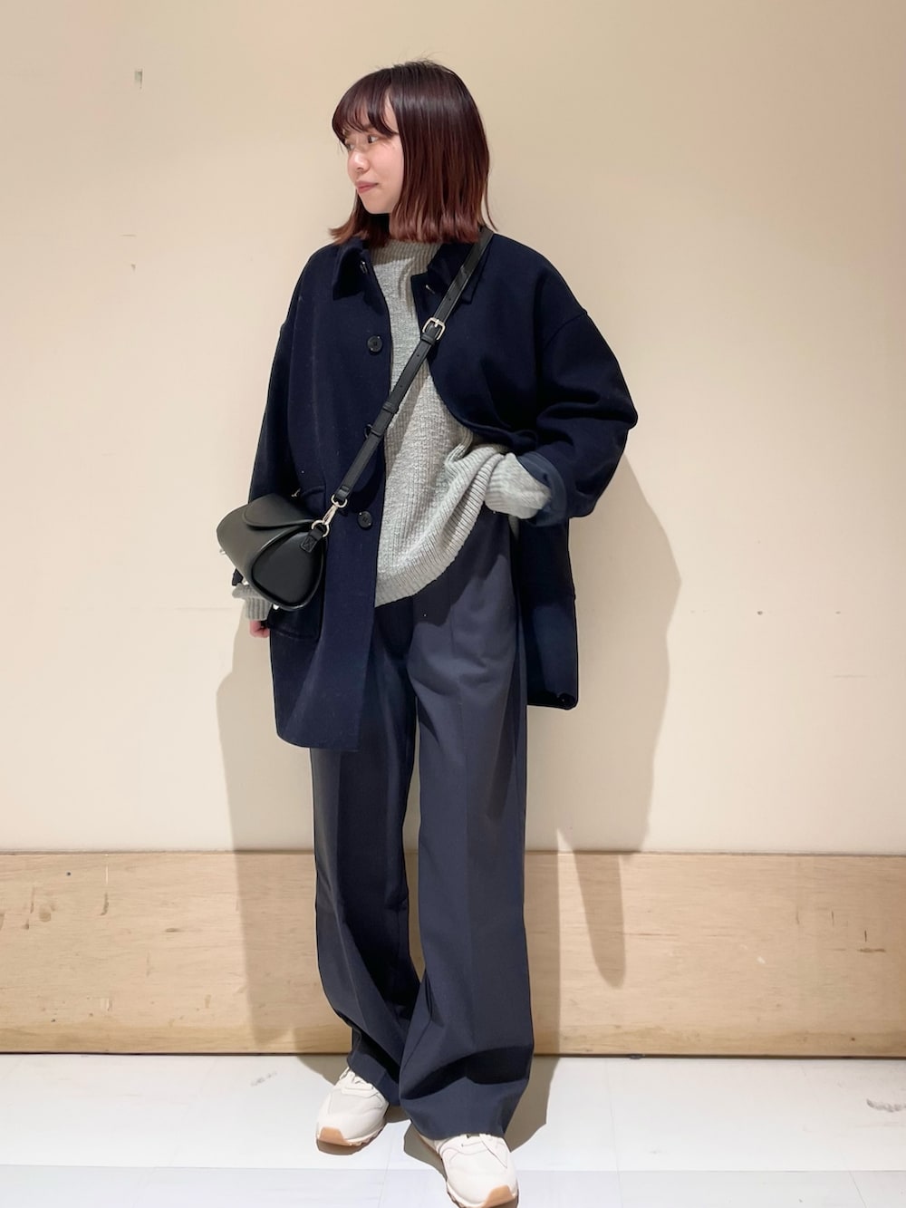 グレー系のニット/セーター、ブルー系のその他アウター、ブラック系のショルダーバッグを着用したレディースの冬コーディネートの2枚目の写真