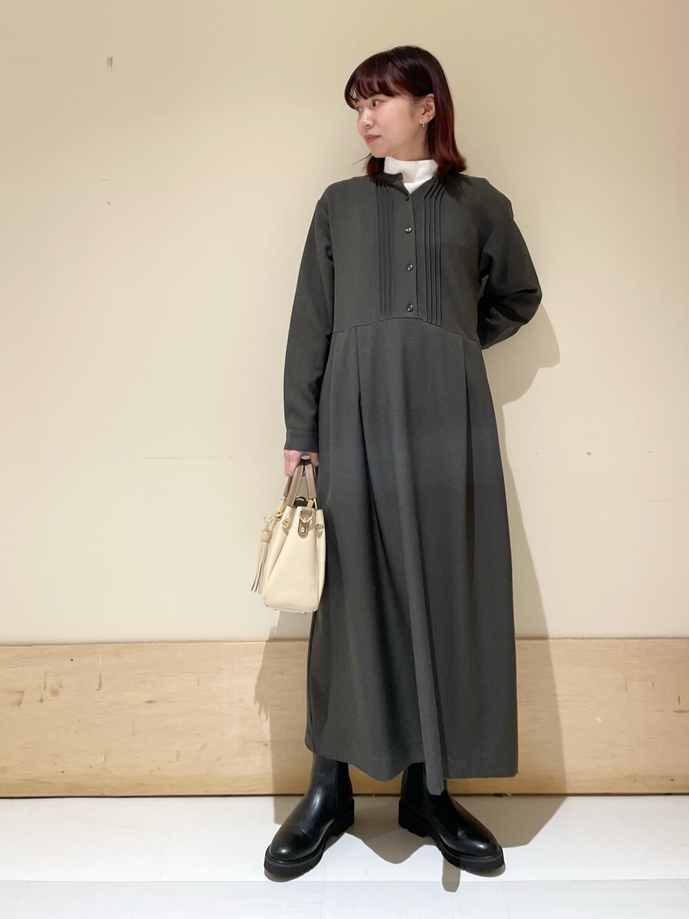 ブラック系のブーツ、グレー系のワンピース、ホワイト系のTシャツ/カットソーを着用したレディースの冬コーディネートの4枚目の写真