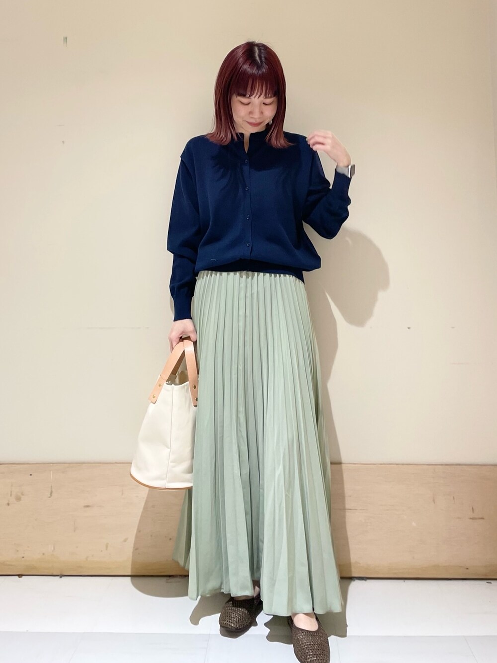 ブルー系のカーディガン/ボレロ、ブラウン系のパンプス、ホワイト系のトートバッグを着用したレディースの春コーディネートの2枚目の写真