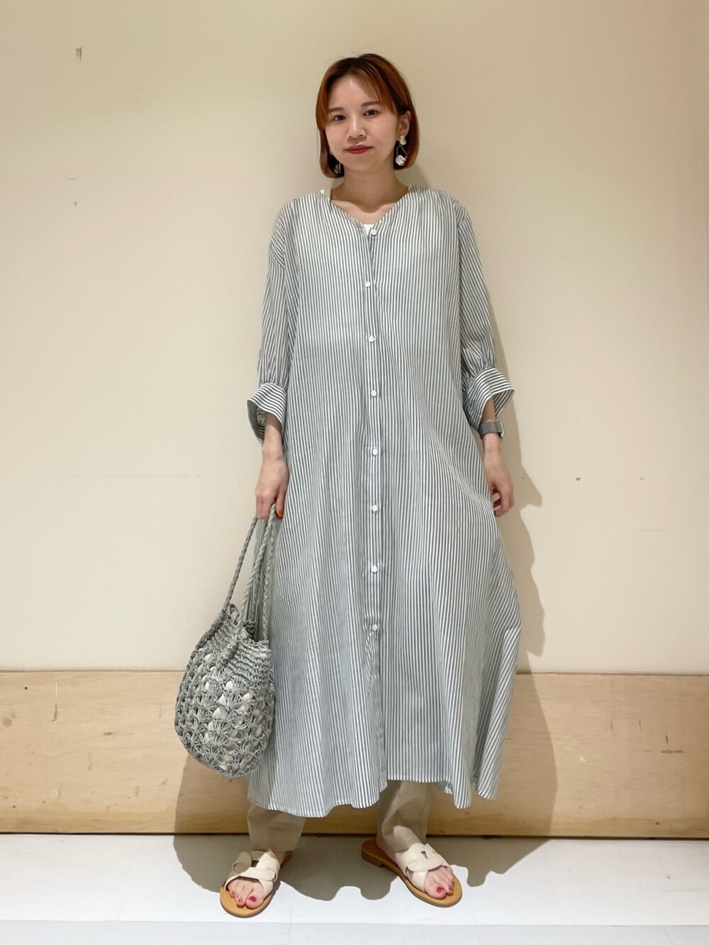 グリーン系のワンピース、グリーン系のかごバッグ、ベージュ系のその他パンツを着用したレディースの夏コーディネートの2枚目の写真