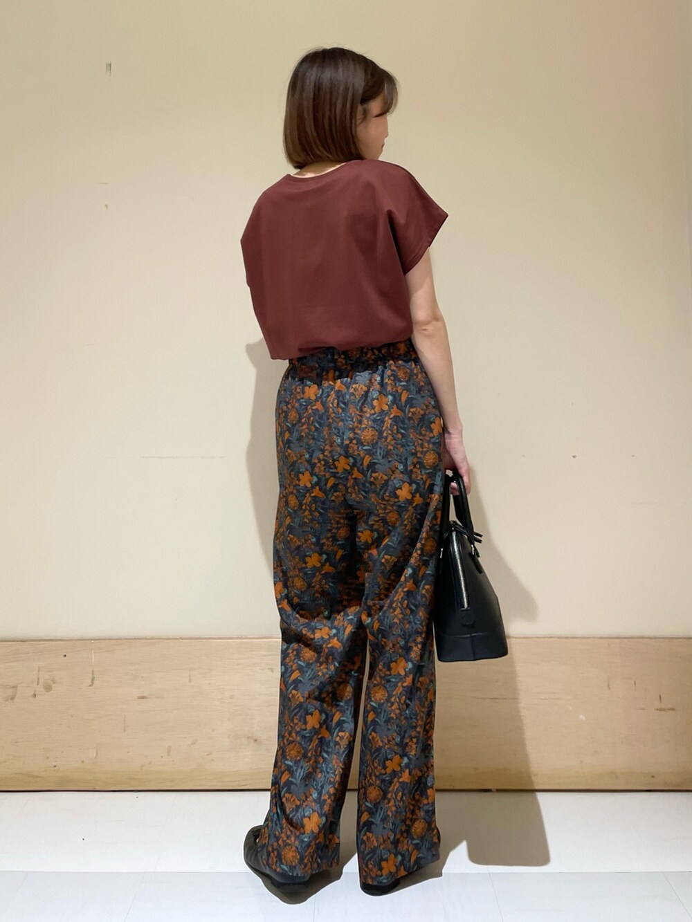 オレンジ系のその他パンツ、レッド系のTシャツ/カットソー、ブラック系のショルダーバッグを着用したレディースの夏コーディネートの6枚目の写真