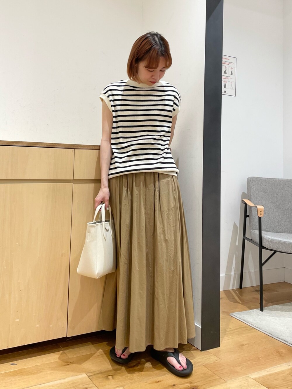 ホワイト系のTシャツ/カットソー、ベージュ系のスカート、ホワイト系のトートバッグを着用したレディースの春コーディネートの3枚目の写真