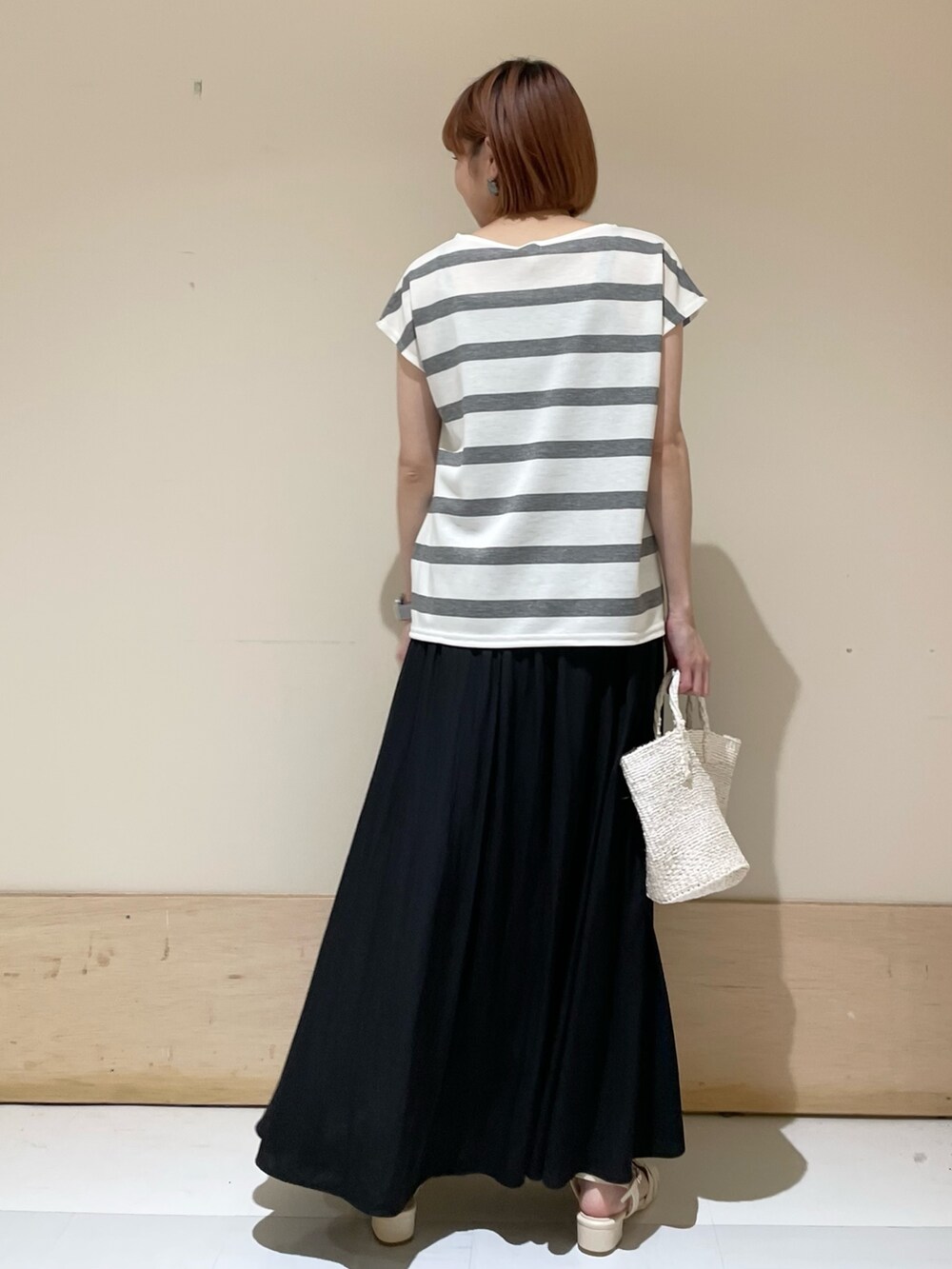 グレー系のTシャツ/カットソー、ホワイト系のハンドバッグ、ホワイト系のサンダルを着用したレディースの春コーディネートの6枚目の写真