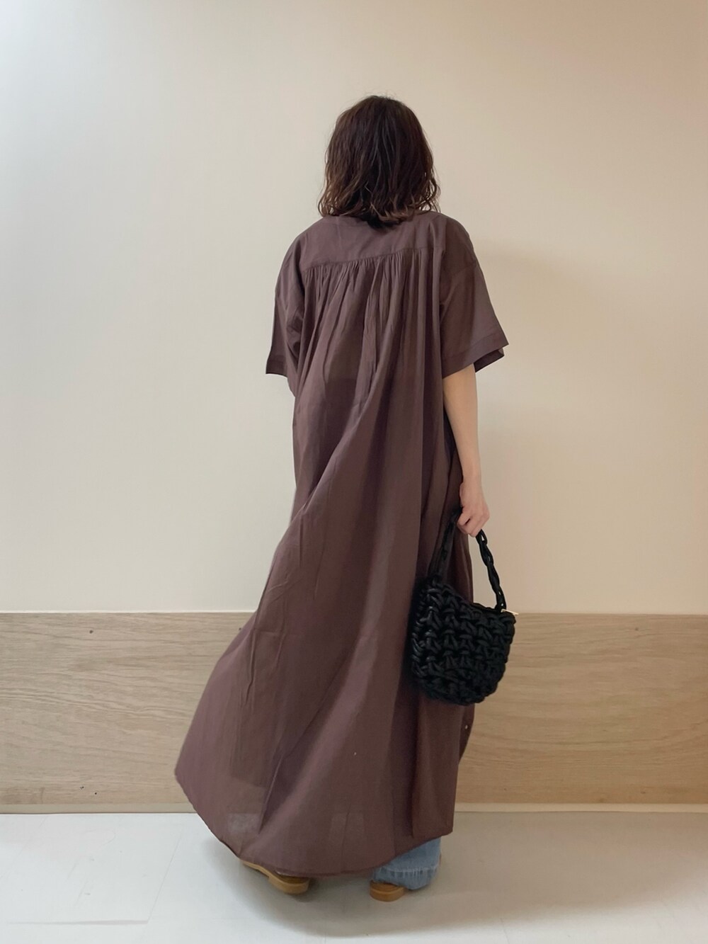 ブルー系のデニムパンツ、ブラック系のサンダル、ブラウン系のワンピースを着用したレディースの春コーディネートの8枚目の写真