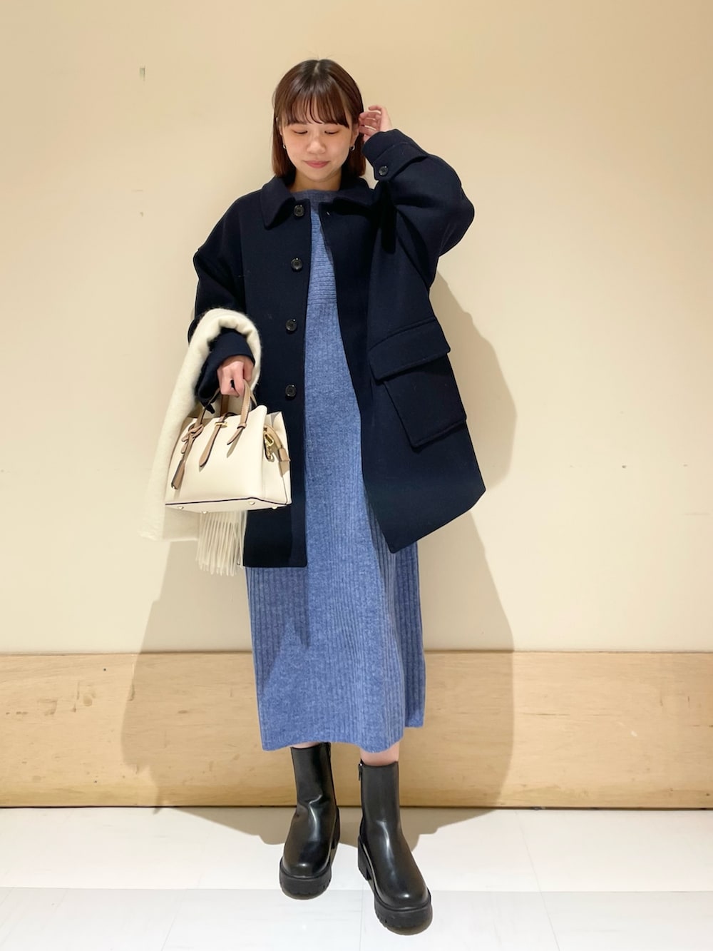 ブルー系のワンピース、ブルー系のその他アウター、ブラック系のブーツを着用したレディースの冬コーディネートの3枚目の写真