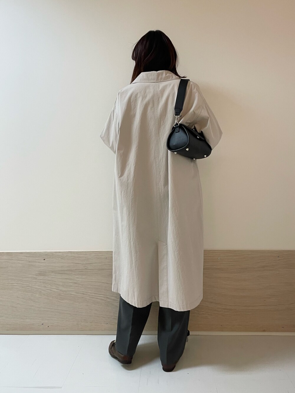 グレー系のその他パンツ、ブラック系のショルダーバッグ、グレー系のステンカラーコートを着用したレディースの春コーディネートの6枚目の写真