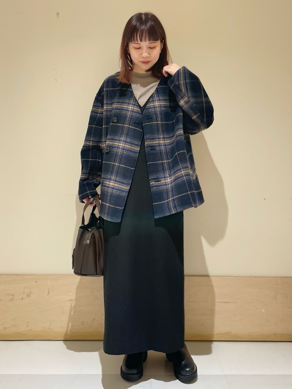ブルー系のノーカラージャケット、ブラック系のワンピース、グレー系のニット/セーターを着用したレディースの冬コーディネートの2枚目の写真