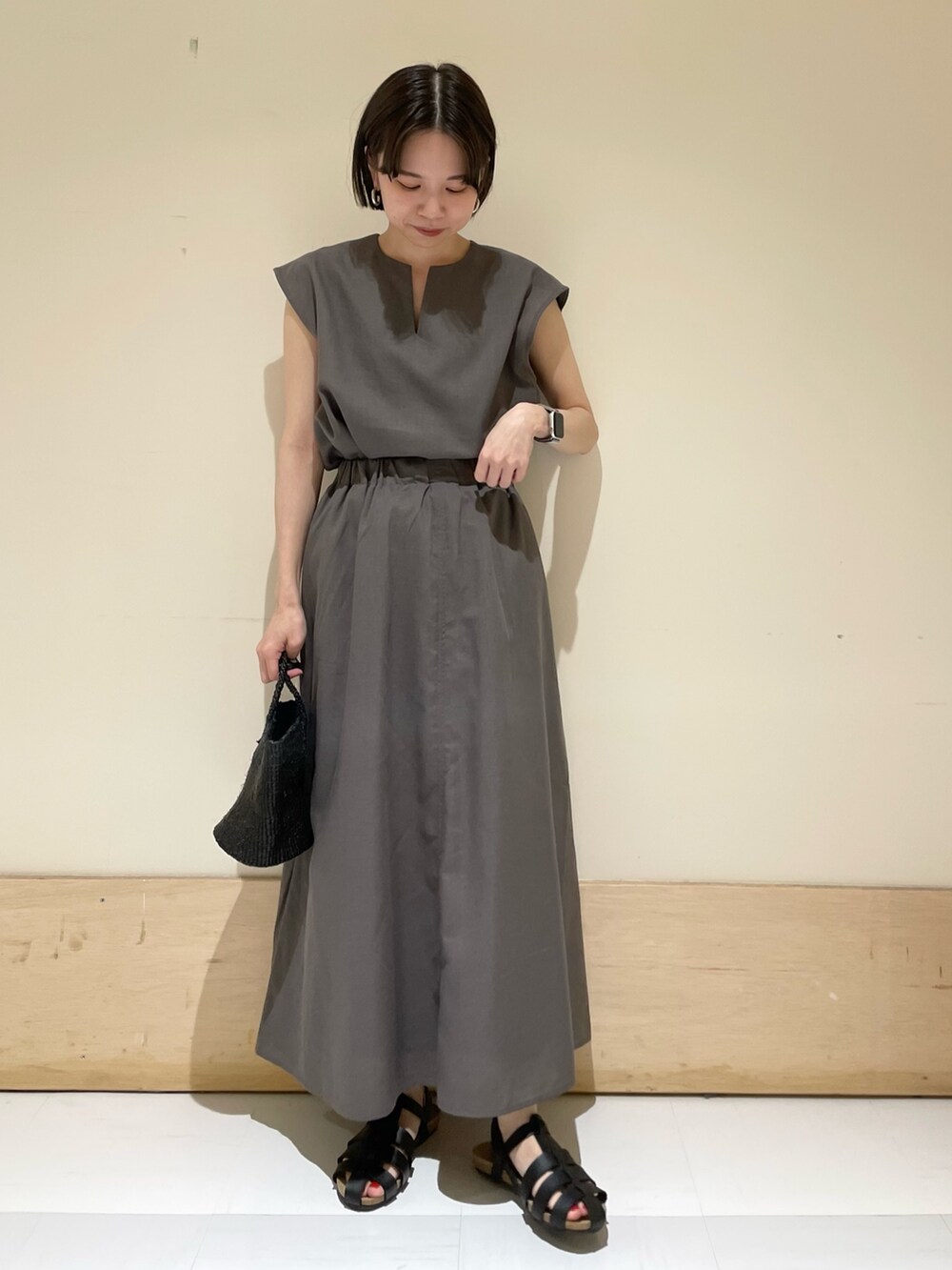 グレー系のシャツ/ブラウス、グレー系のスカート、ブラック系のサンダルを着用したレディースの夏コーディネートの2枚目の写真