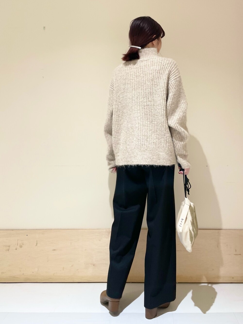 ブラック系のその他パンツ、ベージュ系のニット/セーター、ベージュ系のハンドバッグを着用したレディースの冬コーディネートの7枚目の写真