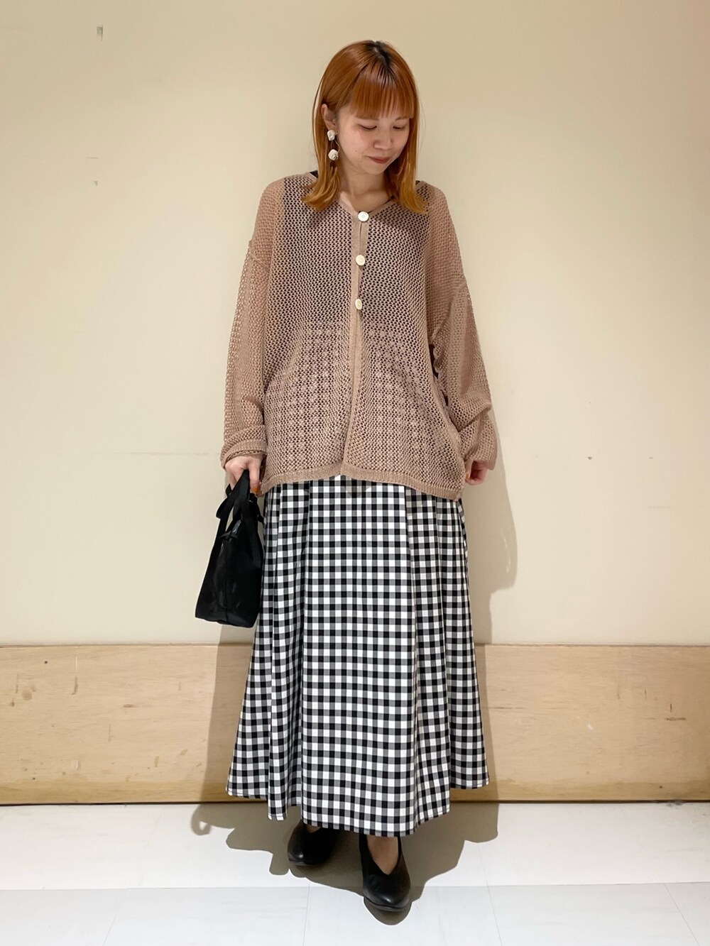 ブラウン系のカーディガン/ボレロ、ブラック系のタンクトップ、ブラック系のショルダーバッグを着用したレディースの春コーディネートの2枚目の写真