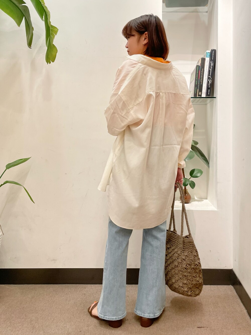 ブルー系のデニムパンツ、ホワイト系のシャツ/ブラウス、オレンジ系のTシャツ/カットソーを着用したレディースの春コーディネートの2枚目の写真