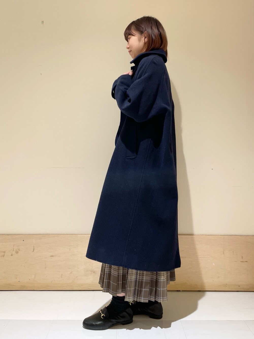 ブラック系のニット/セーター、ホワイト系のショルダーバッグ、ブラウン系のスカートを着用したレディースの冬コーディネートの5枚目の写真