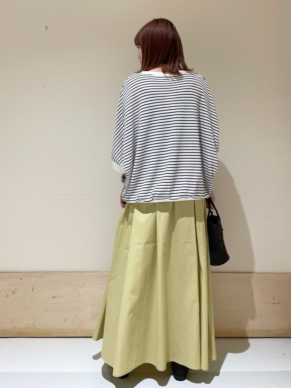 ホワイト系のTシャツ/カットソー、イエロー系のスカート、ブラック系のローファーを着用したレディースの春コーディネートの4枚目の写真