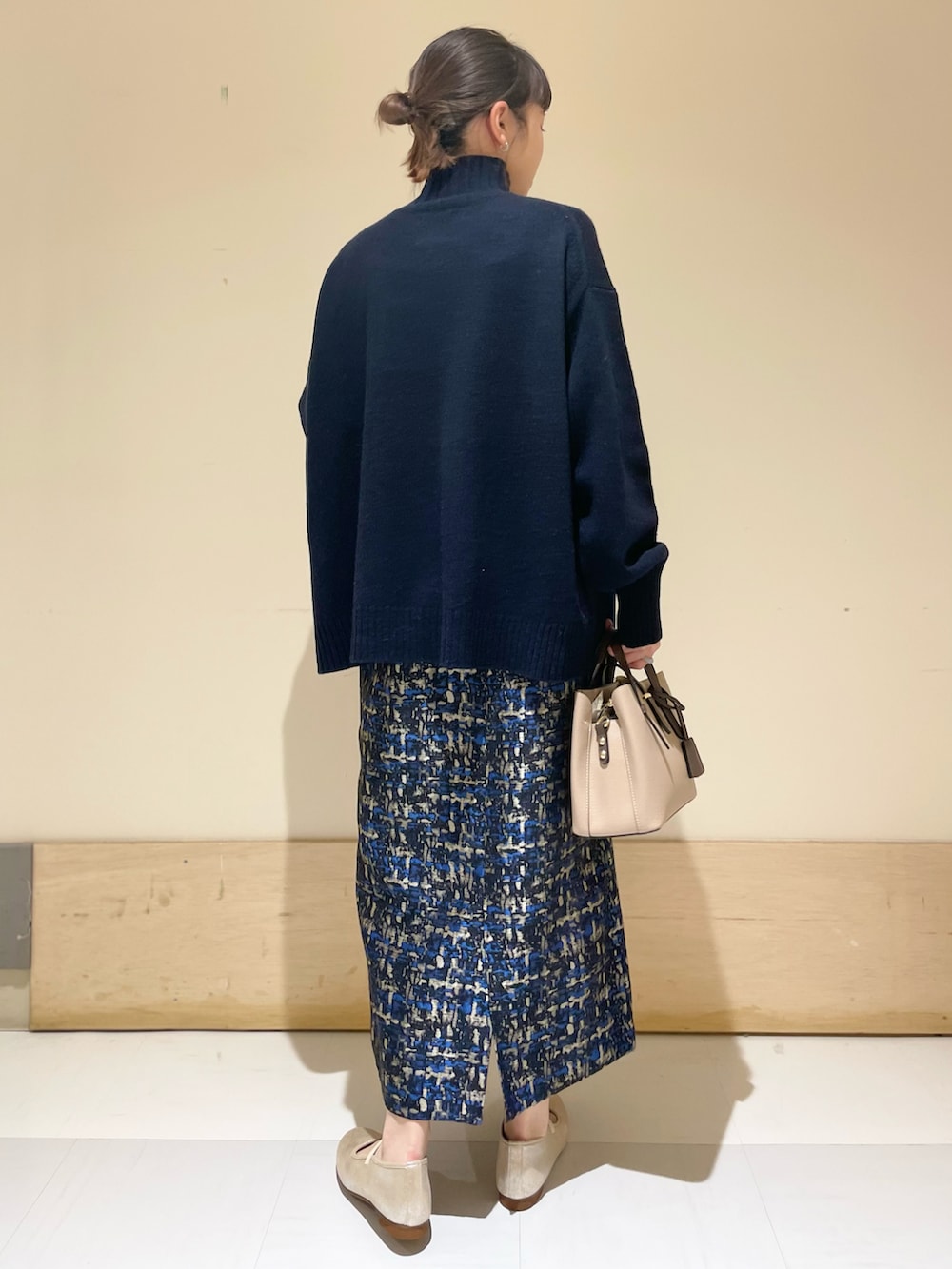 ブルー系のニット/セーター、ブルー系のスカート、ゴールド系のその他シューズを着用したレディースの冬コーディネートの2枚目の写真