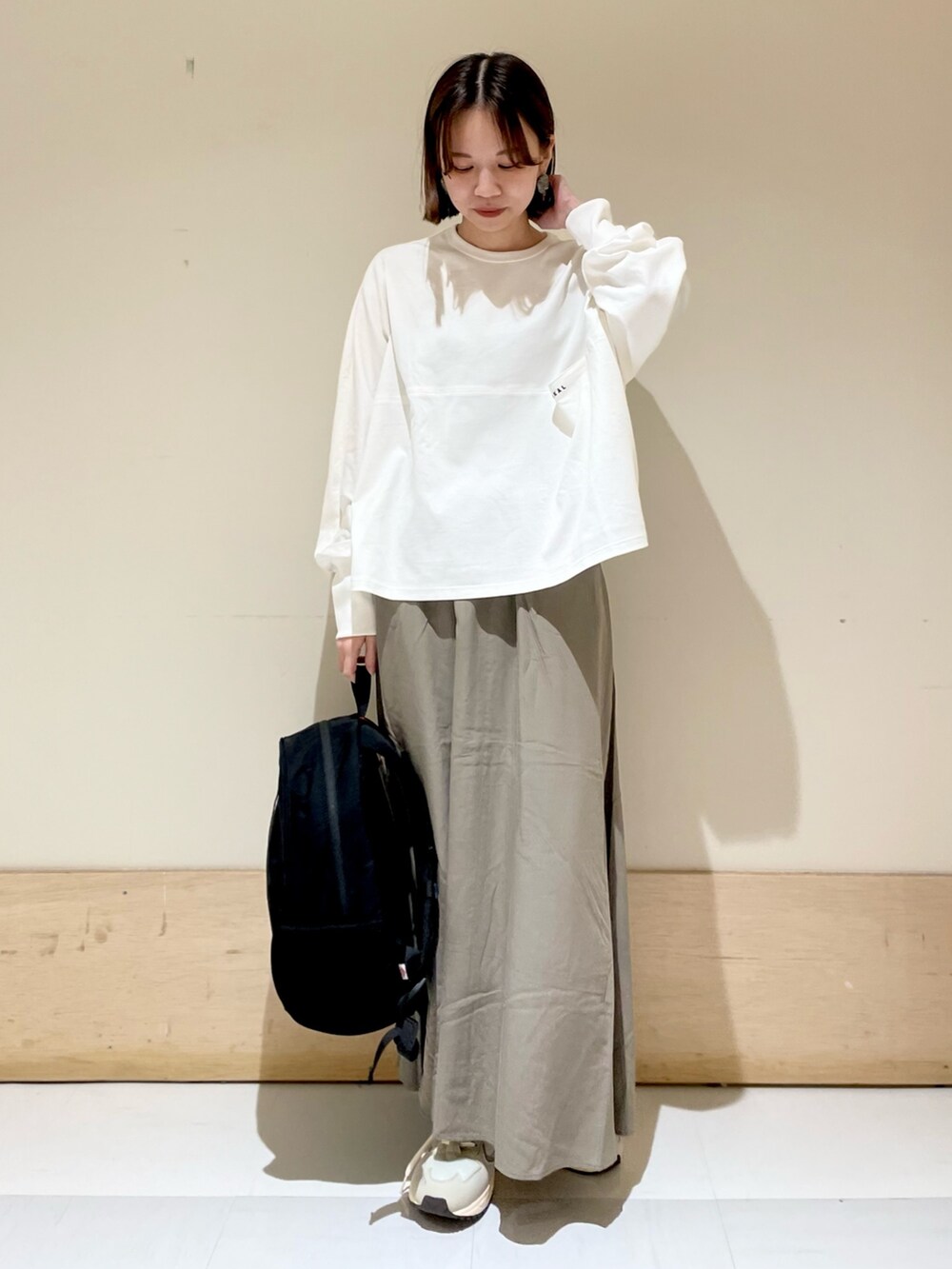 ホワイト系のTシャツ/カットソー、グリーン系のスカート、グレー系のスニーカーを着用したレディースの夏コーディネートの3枚目の写真