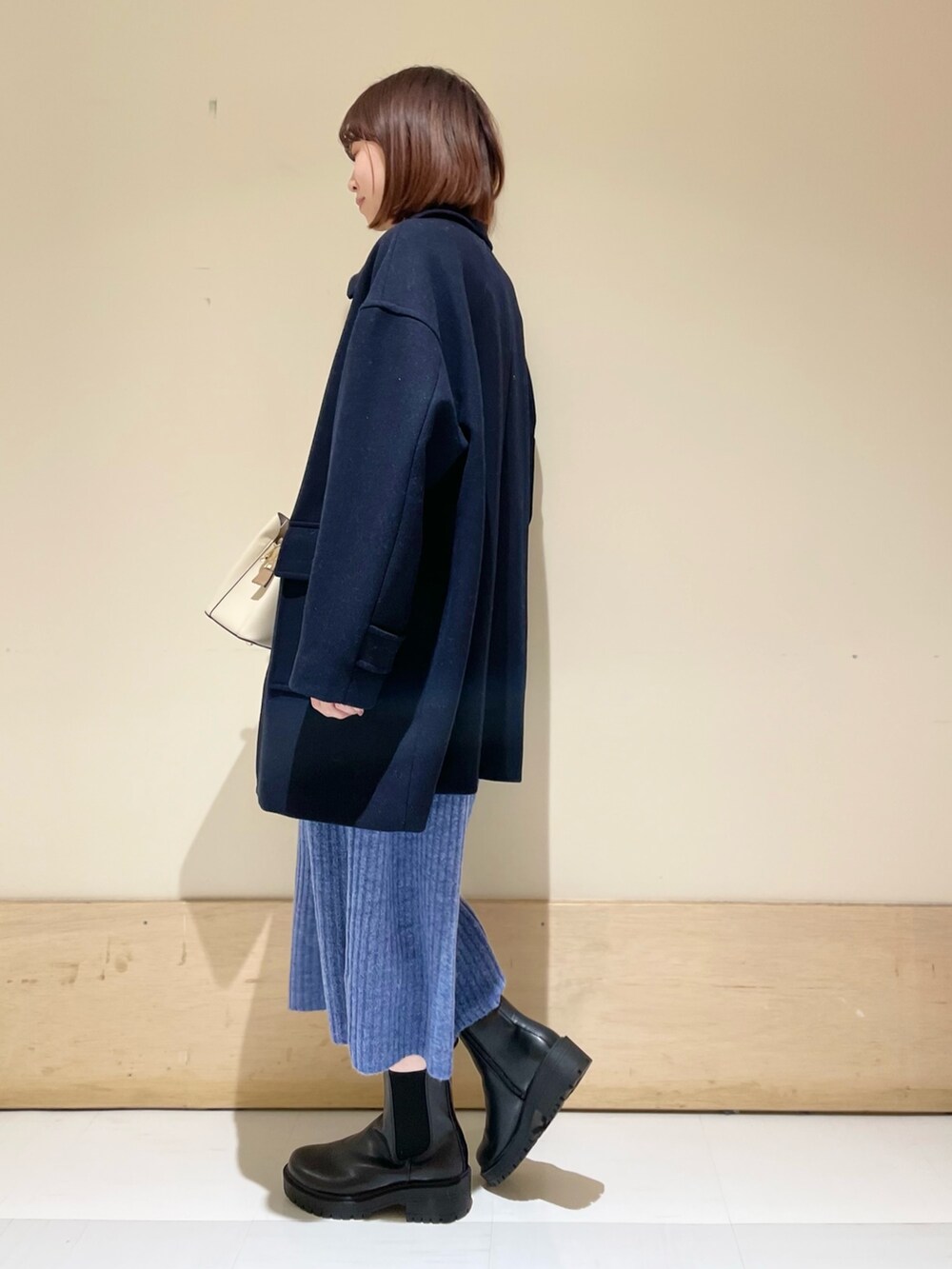 ブルー系のワンピース、ブルー系のその他アウター、ブラック系のブーツを着用したレディースの冬コーディネートの5枚目の写真